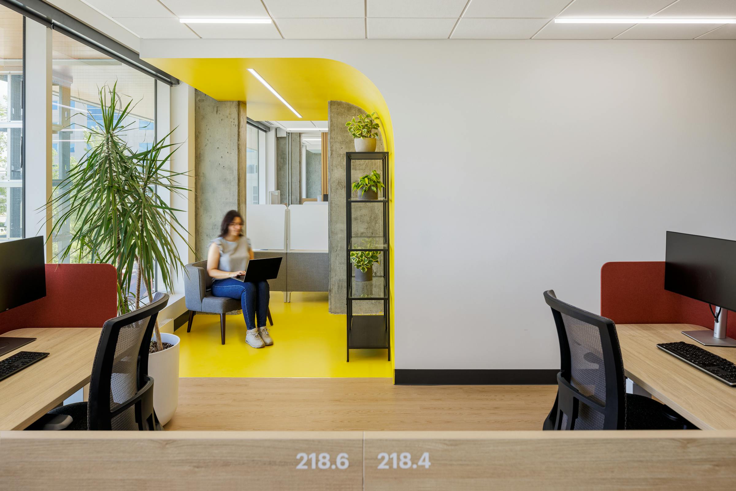 Bureau au design contemporain avec une arche jaune vif et des plantes décoratives.