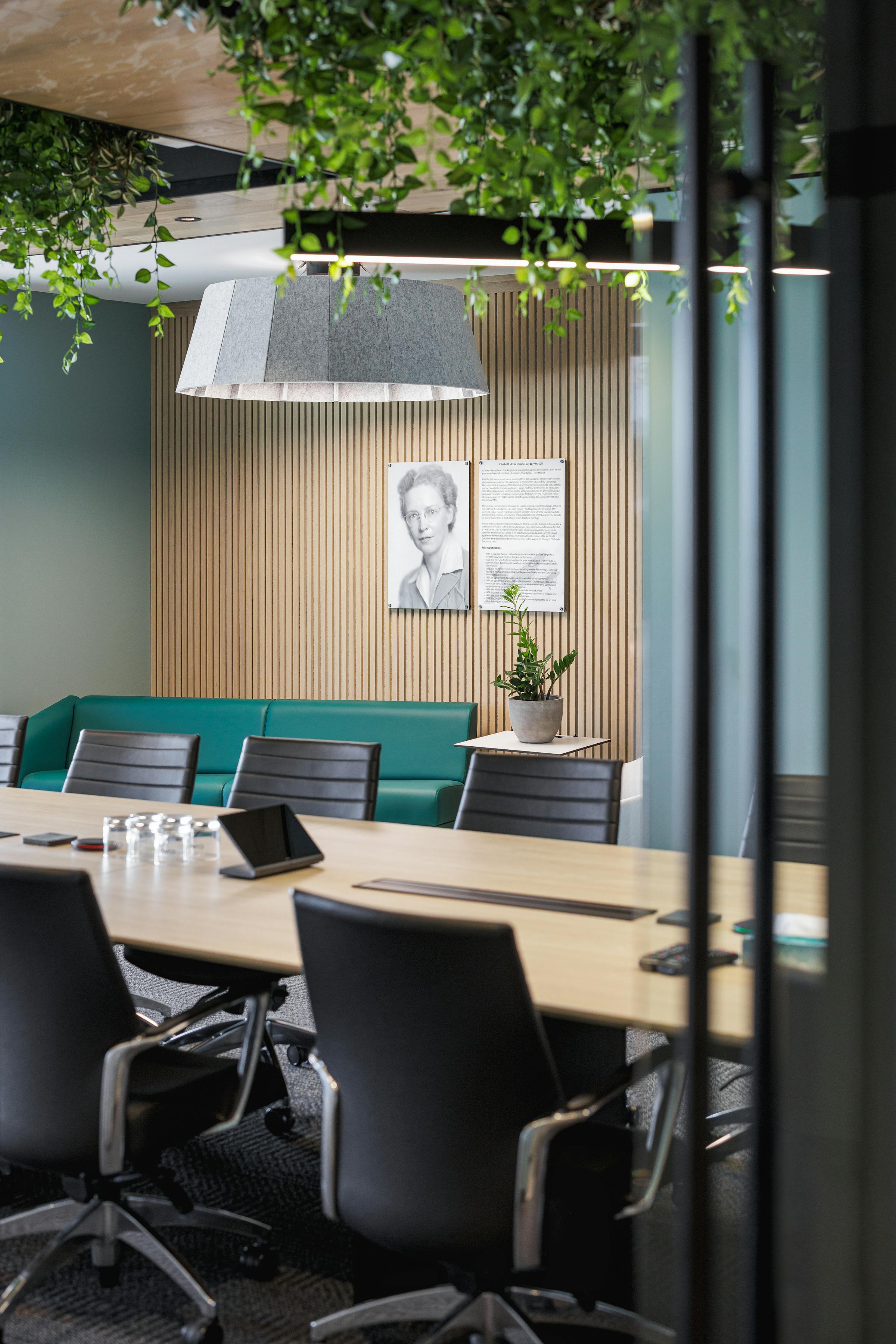 Zone collaborative avec un mur végétalisé et des sièges modulaires.