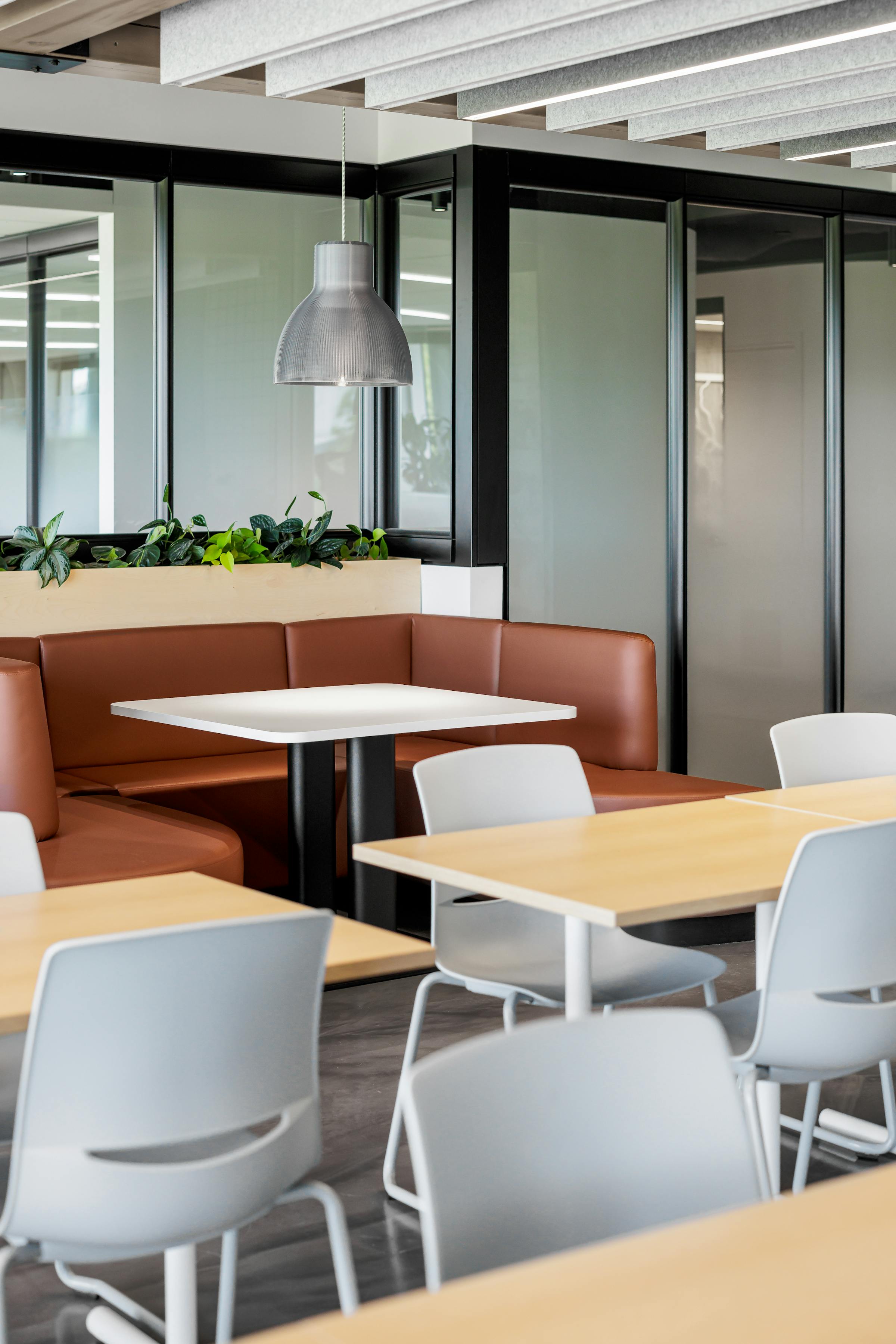 Cafétéria lumineuse avec des poutres en bois et de grandes baies vitrées.