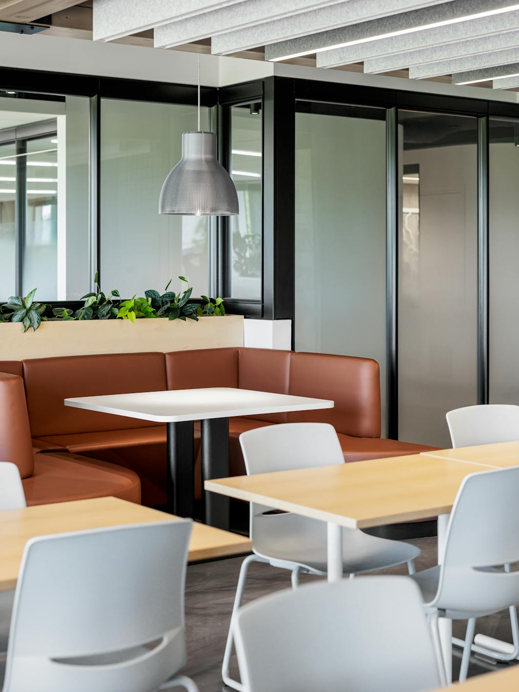 Cafétéria lumineuse avec des poutres en bois et de grandes baies vitrées.