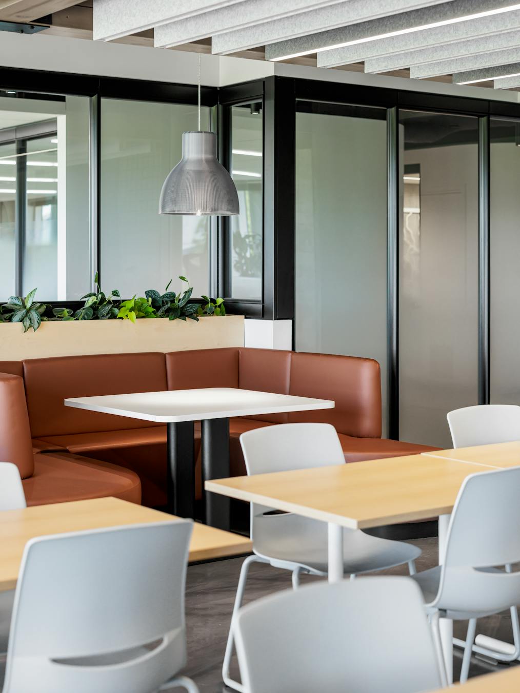 Cafétéria lumineuse avec des poutres en bois et de grandes baies vitrées.