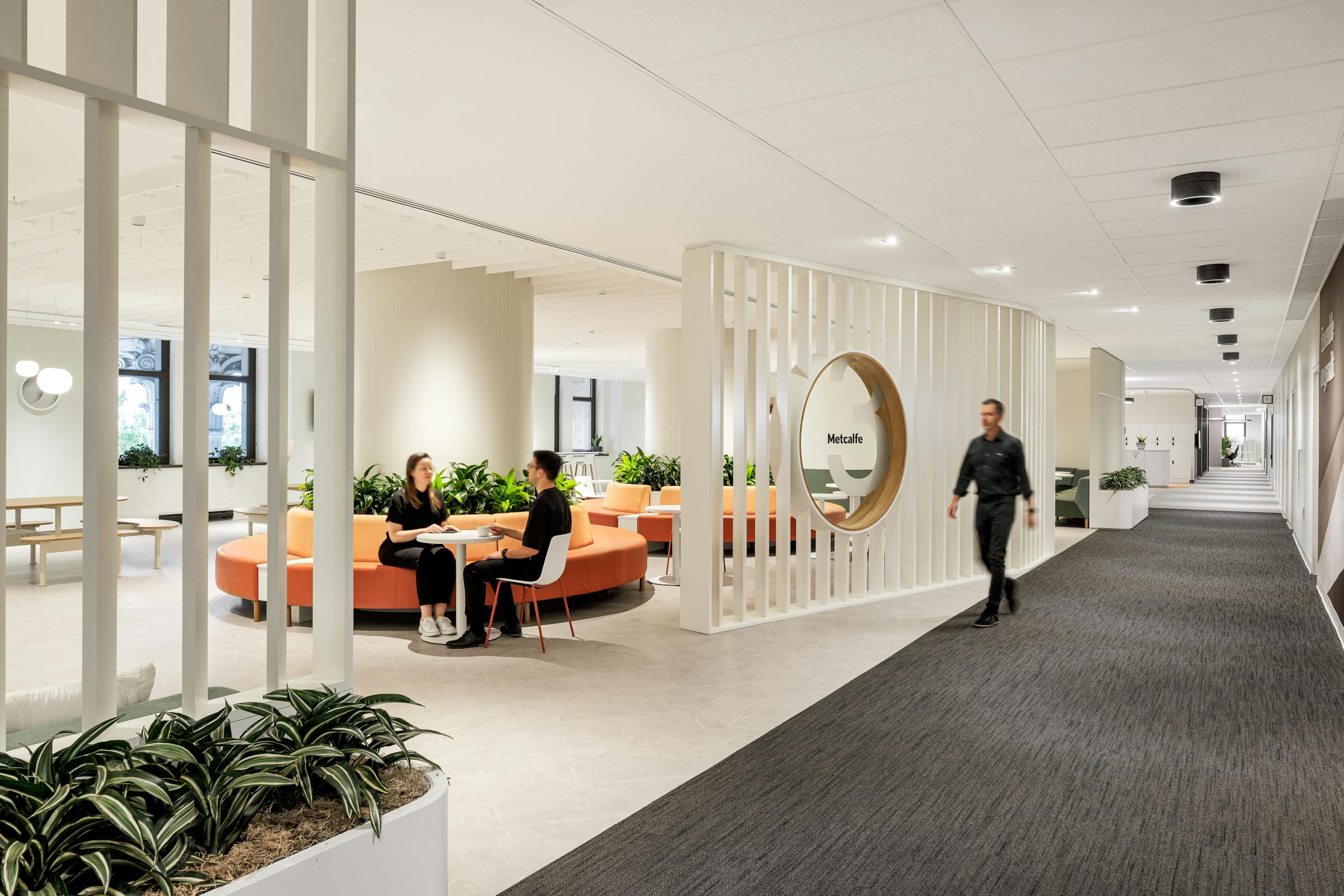 Passage lumineux ouvert sur une zone de détente et de travail, conçu avec un design architectural fluide.