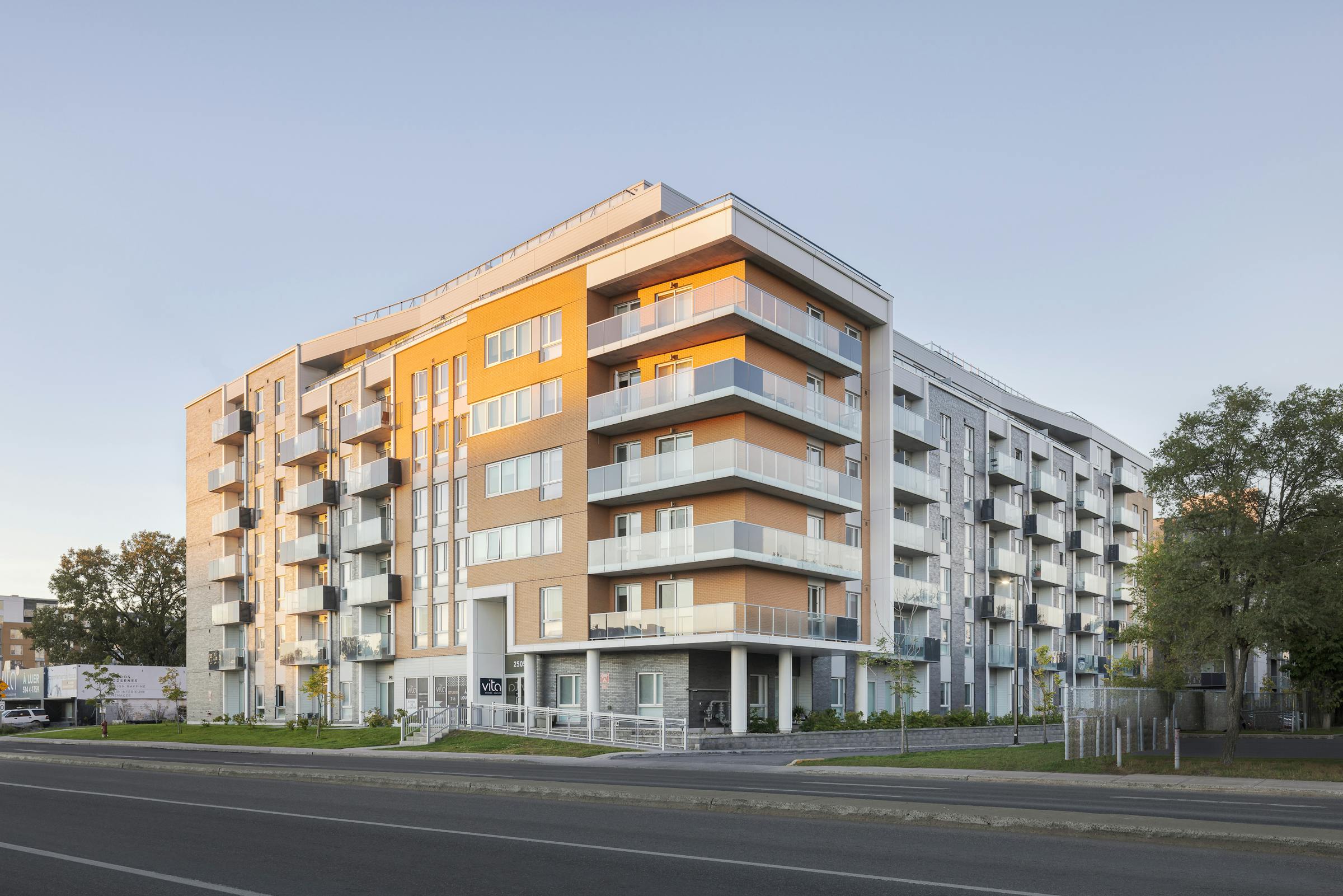 Photographie professionnelle d'architecture d'un immeuble au lever du soleil. Le soleil levant éclaire la façade.