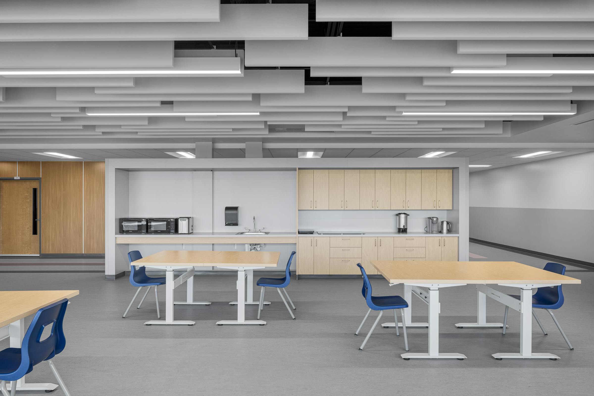 Aménagement d’un espace repas dans une école spécialisée, favorisant l’autonomie et la socialisation dans un cadre architectural fonctionnel.