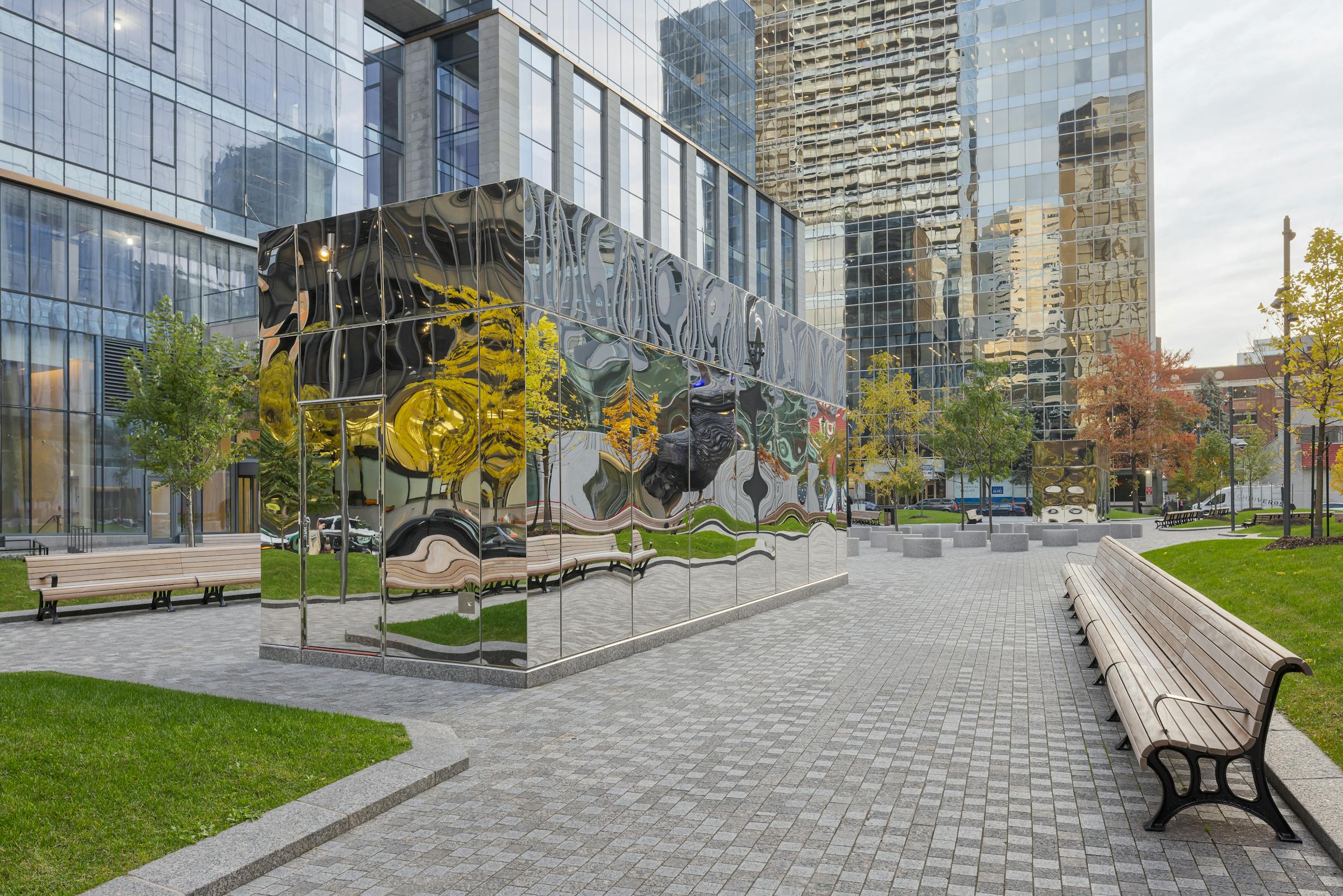 Vue de la place centrale avec kiosques réfléchissants intégrés au sol.