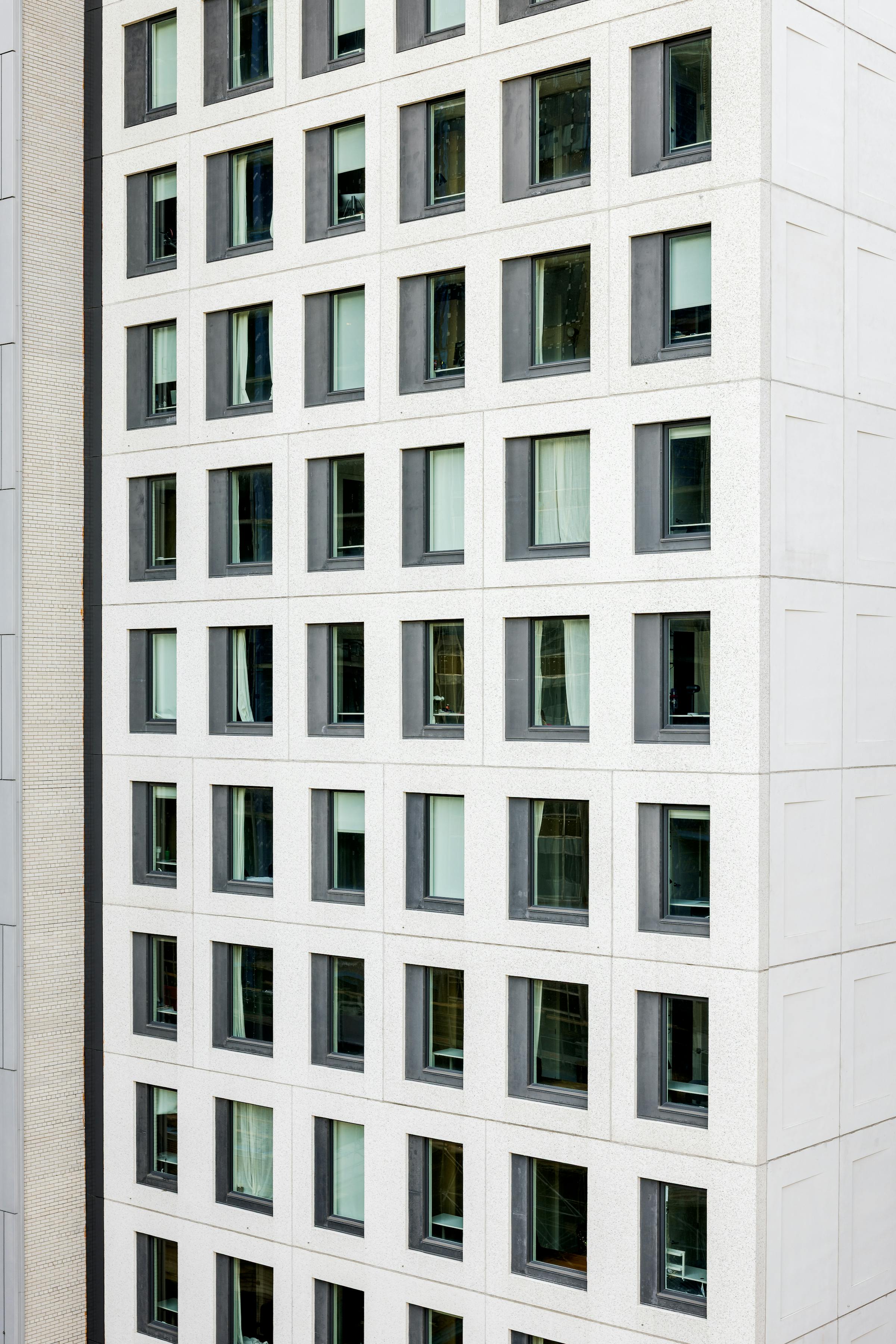 Façade animée par une grille régulière de fenêtres légèrement en retrait.
