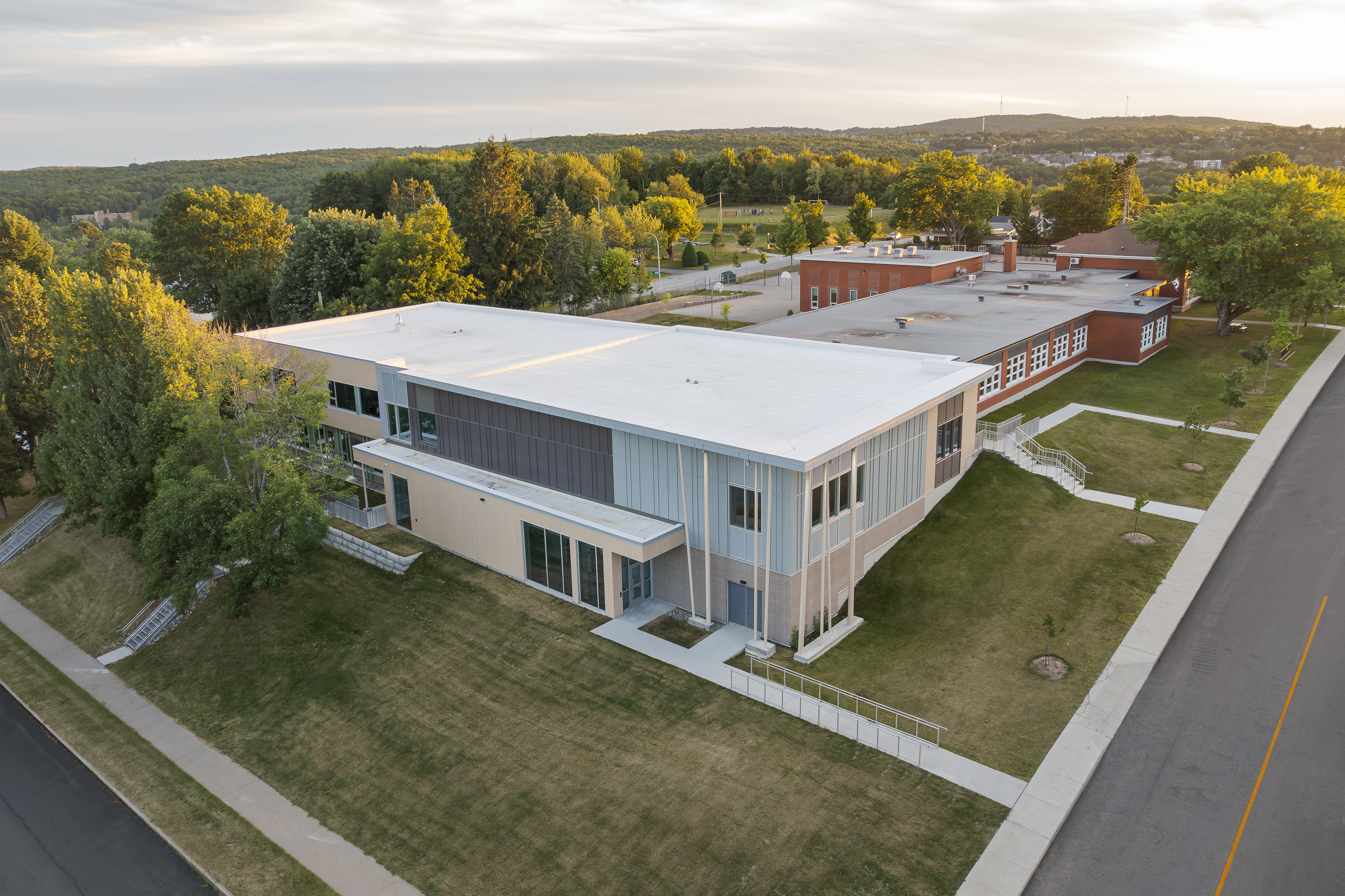 Vue aérienne par drone du complexe scolaire au cœur de la végétation.