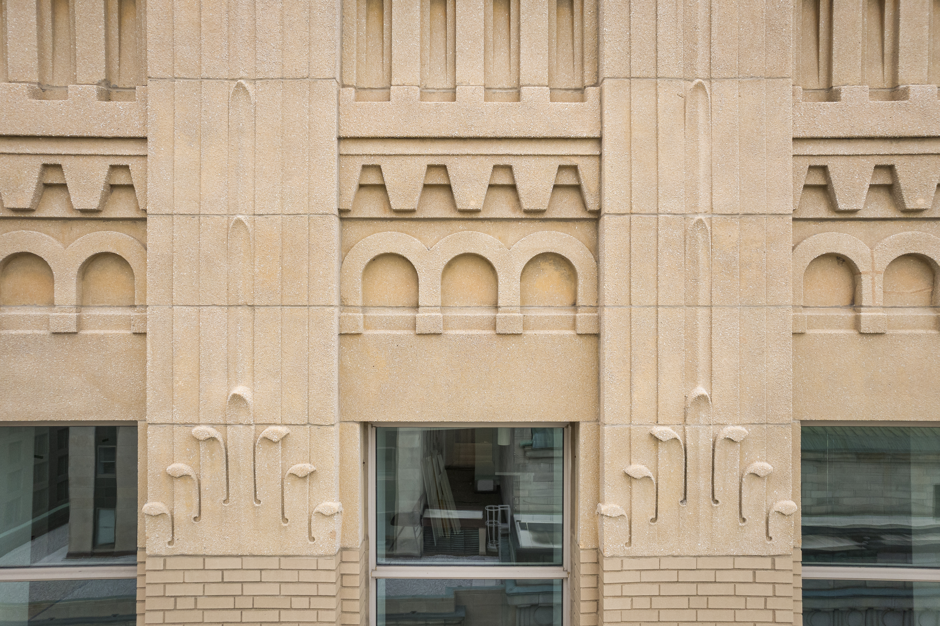 Détail architectural des fenêtres encastrées et de leurs encadrements de pierre.