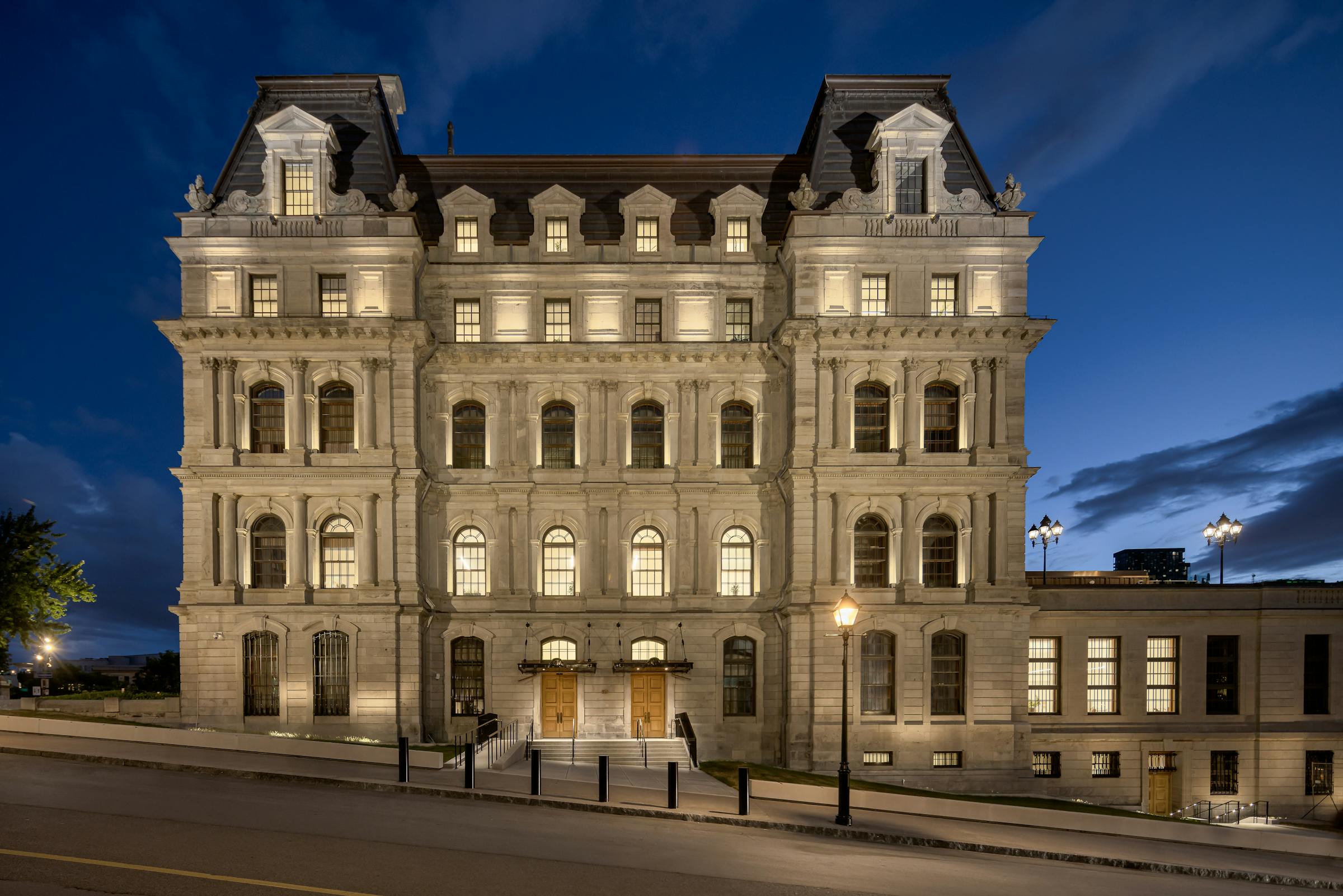 Photographie d’ambiance du bâtiment patrimonial dans le Vieux-Montréal de nuit.