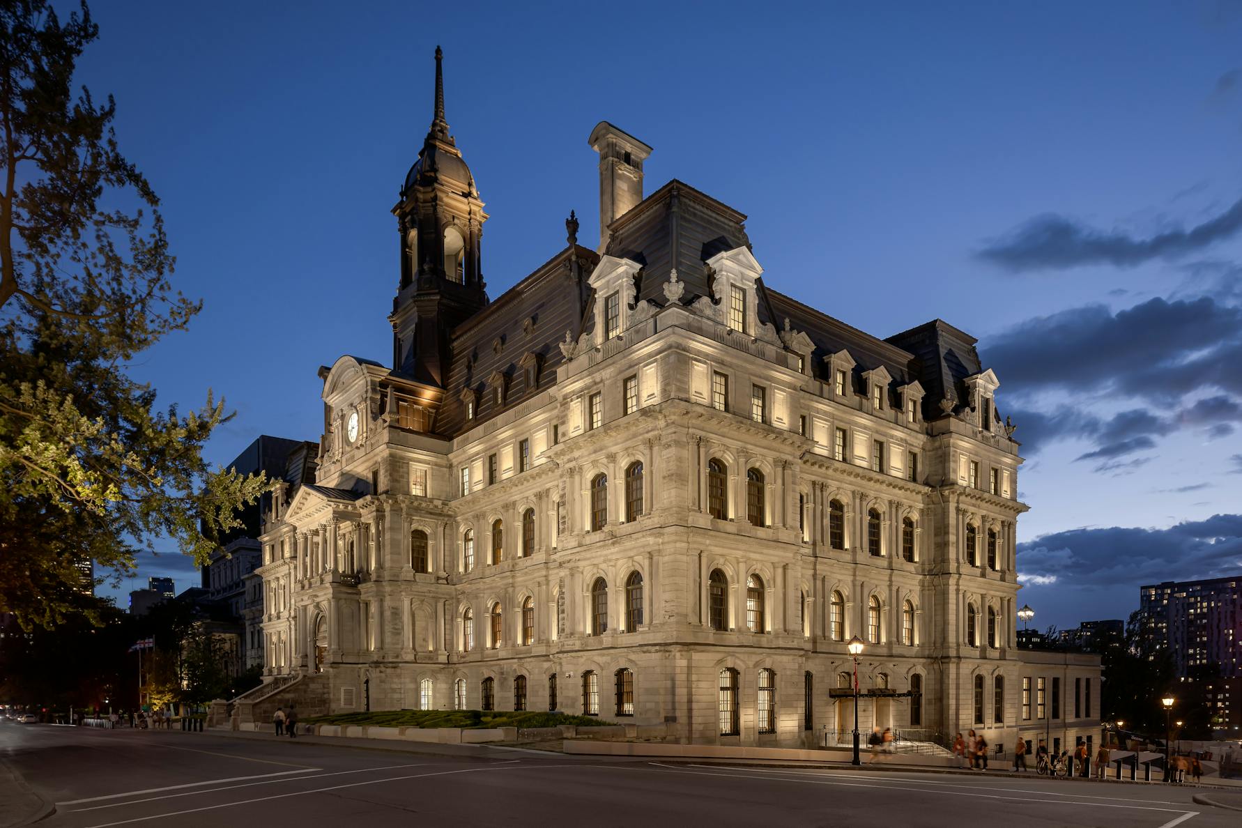 Vue de la façade de l’Hôtel de Ville à la tombée du jour, captée en lumière mixte naturelle et artificielle.