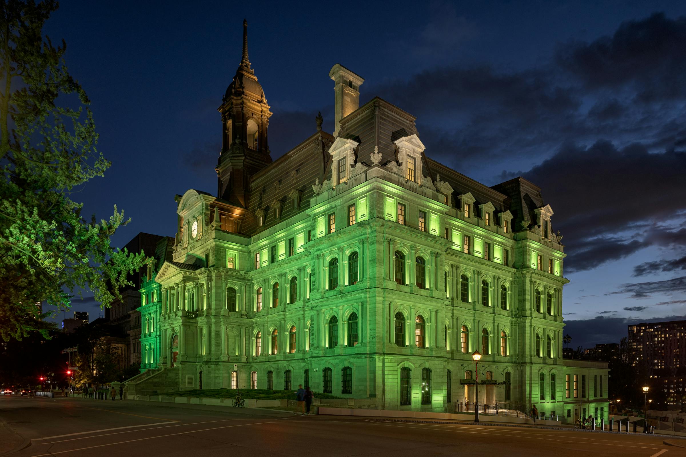 Vue d’ensemble du bâtiment patrimonial sous un éclairage programmable aux teintes changeantes.