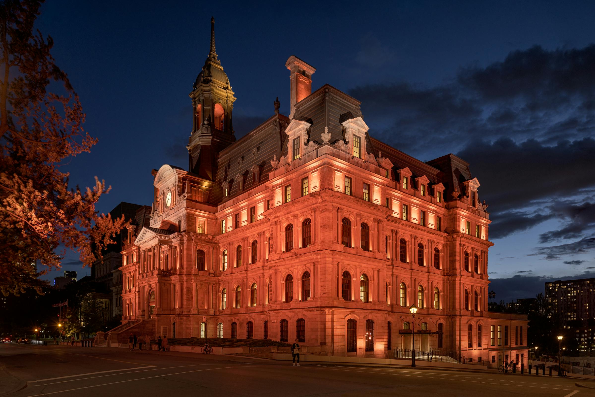 Jeu de lumière colorée sur les colonnes et ornements du bâtiment historique.