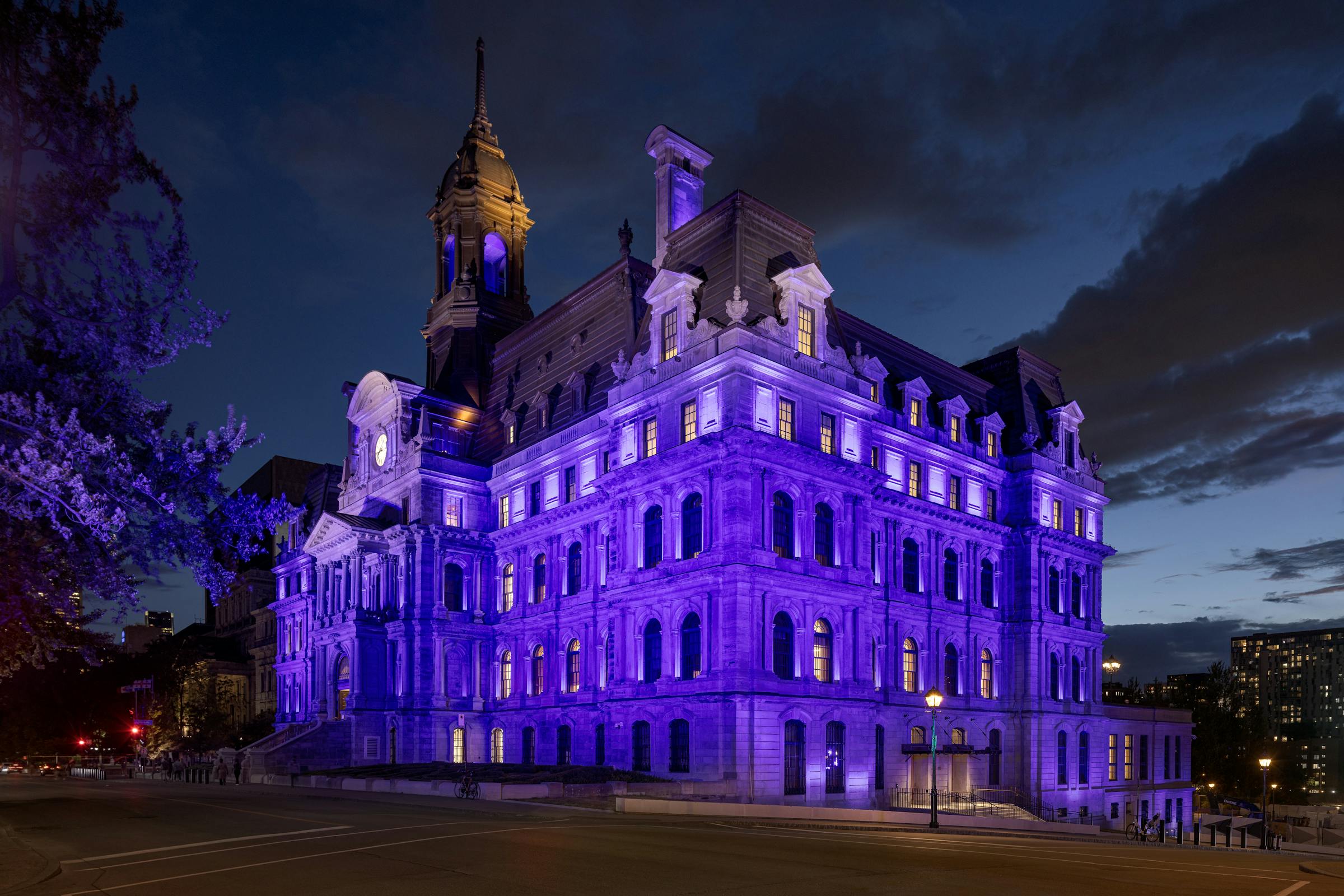 Photographie de la façade principale baignée de lumière colorée au cœur du Vieux-Montréal.