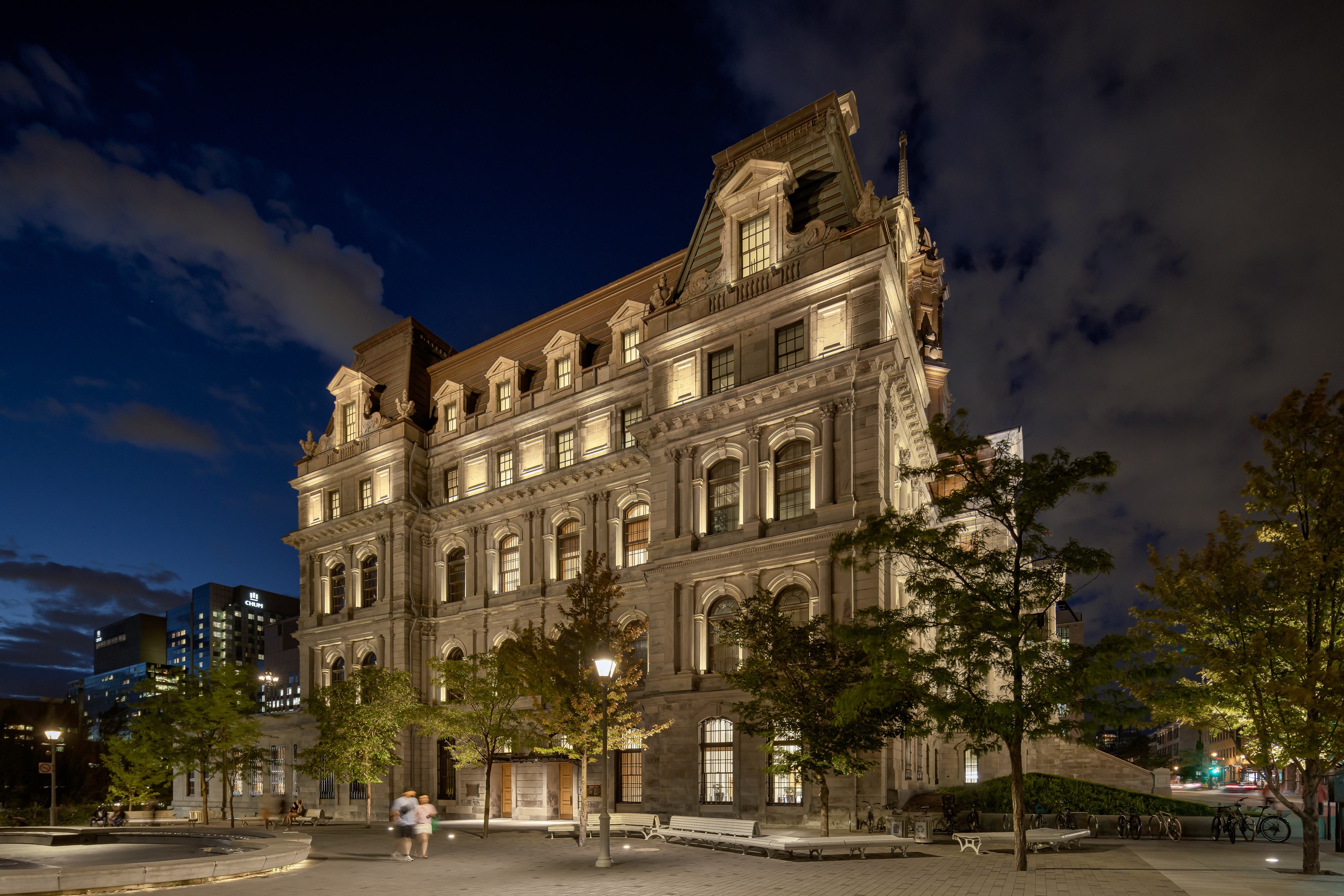 Vue à niveau de rue, captant la monumentalité du bâtiment illuminé.