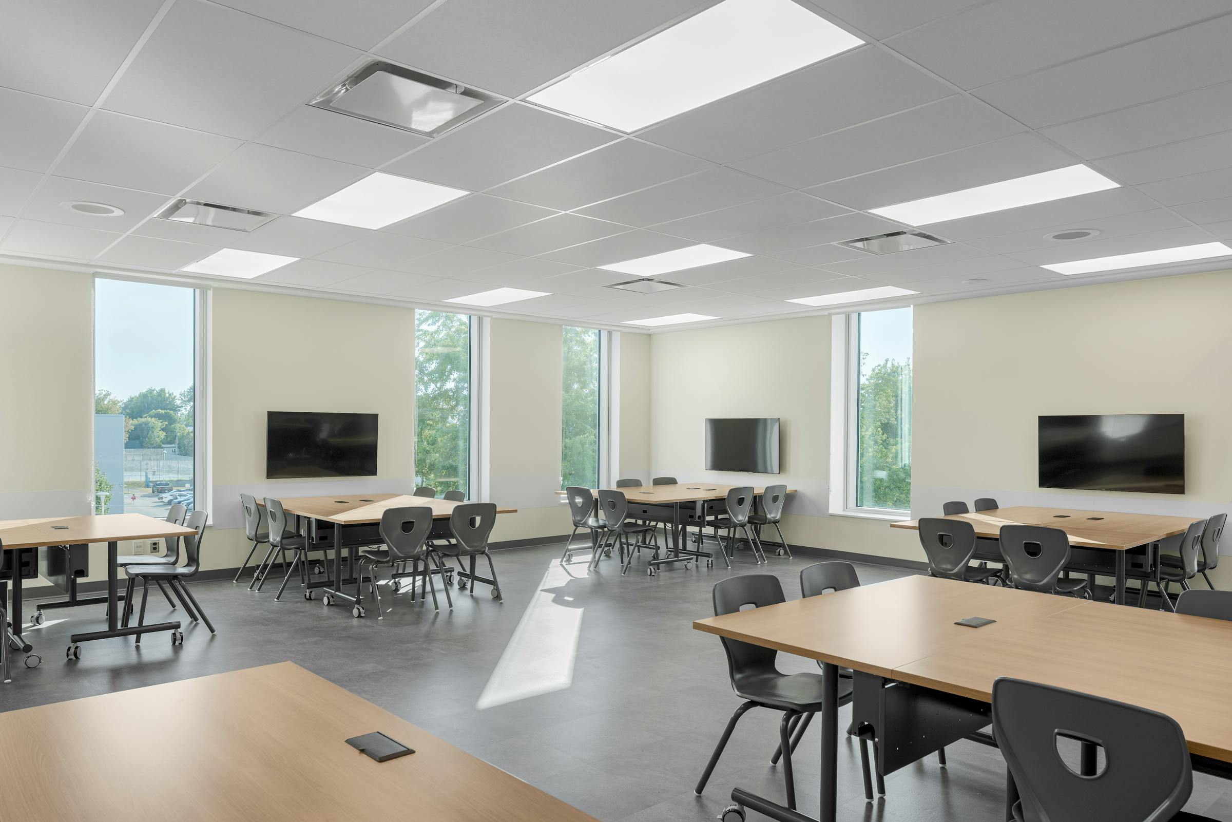 Vue intérieure d’une classe avec fenestration généreuse et ambiance apaisante.