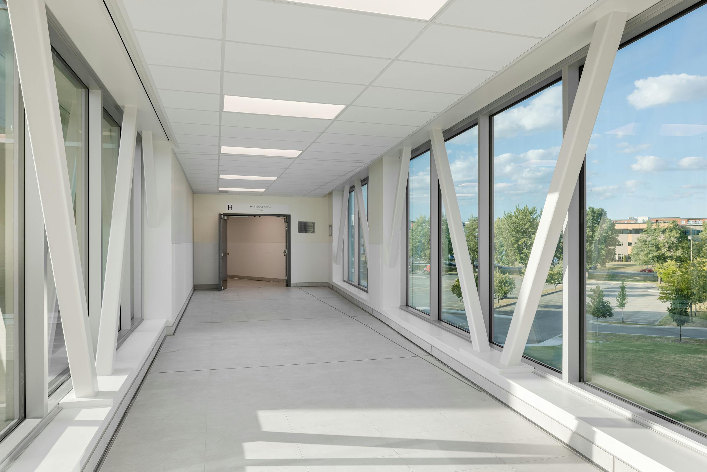 Corridor vitré offrant une perspective sur la rue Duquet et les espaces d’étude.