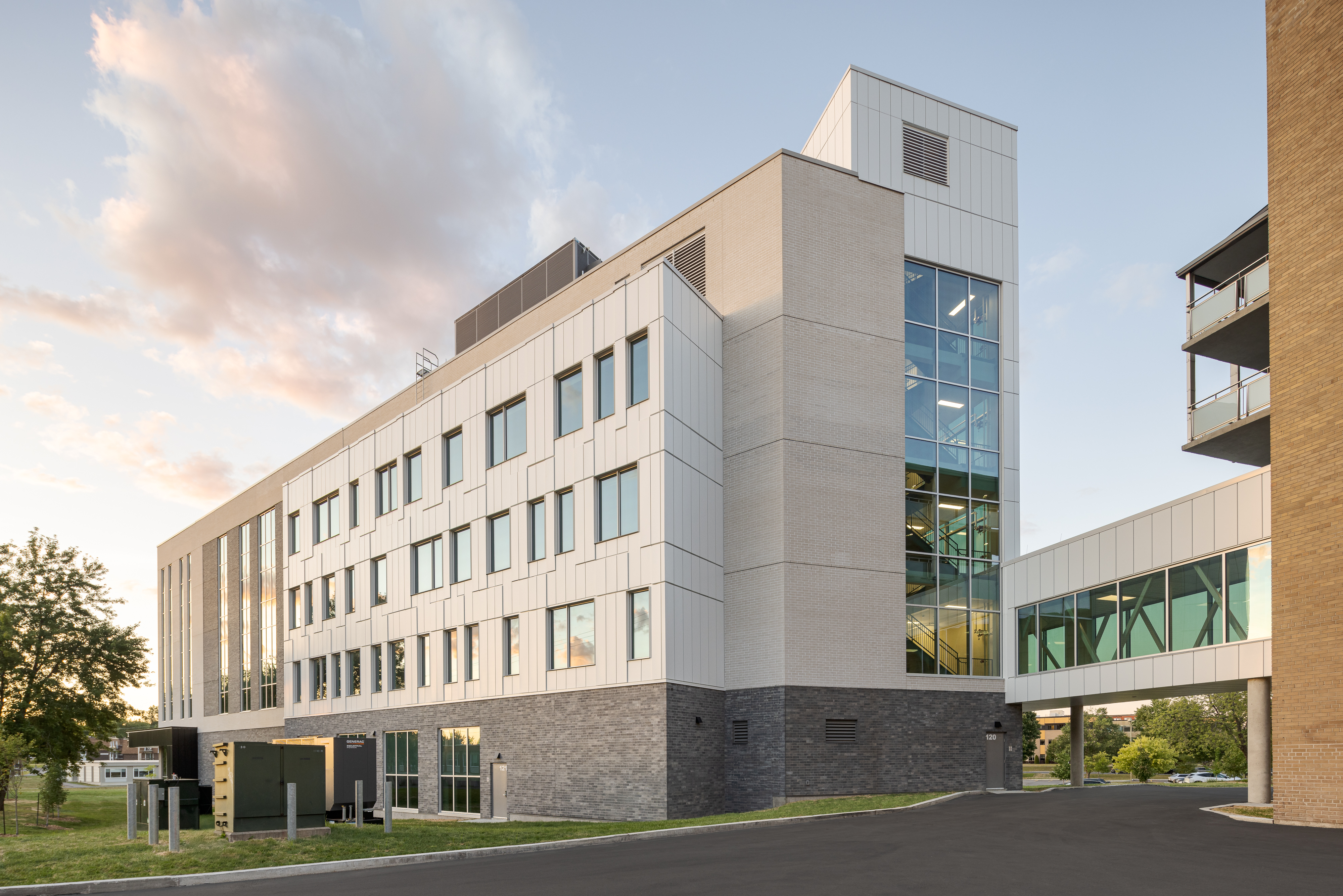 Façade vitrée captant la lumière naturelle et les reflets du ciel.