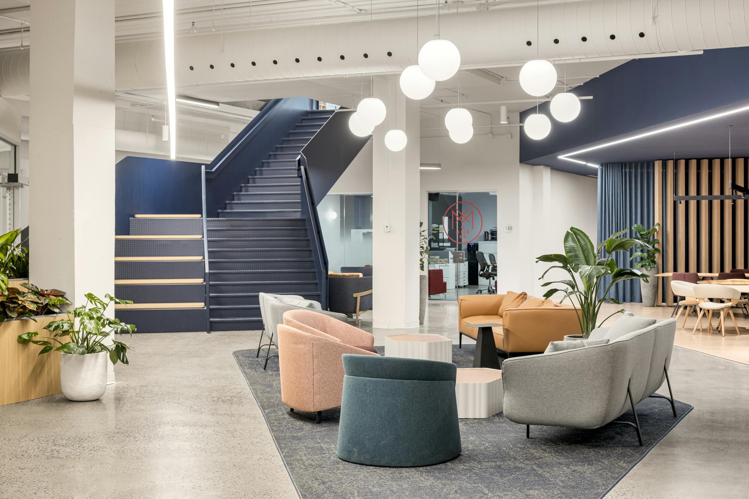 Photographie d’un espace commun moderne avec béton apparent et éléments architecturaux colorés