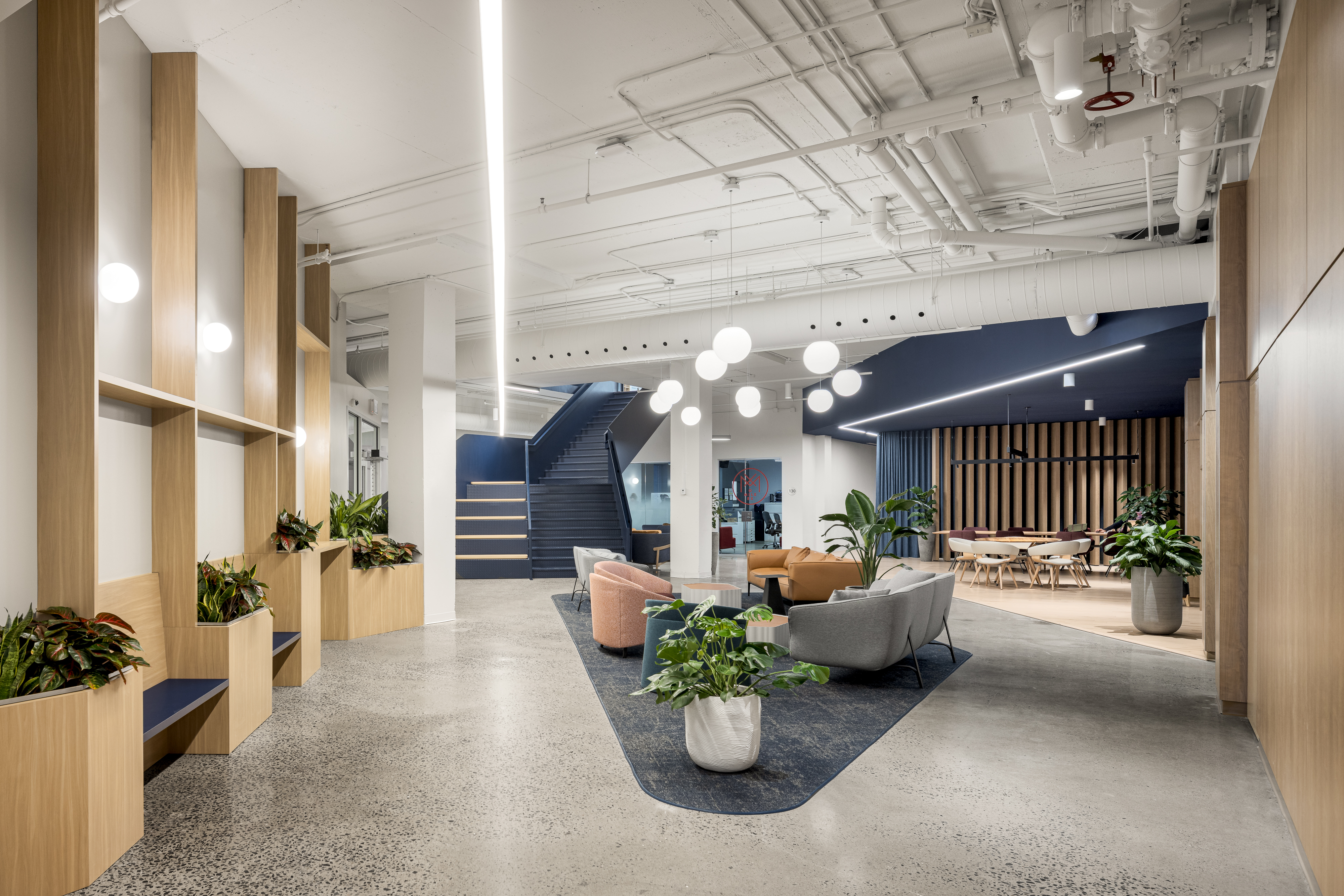 Photographie intérieure d’un environnement de travail avec aménagement biophilique et mobilier contemporain.