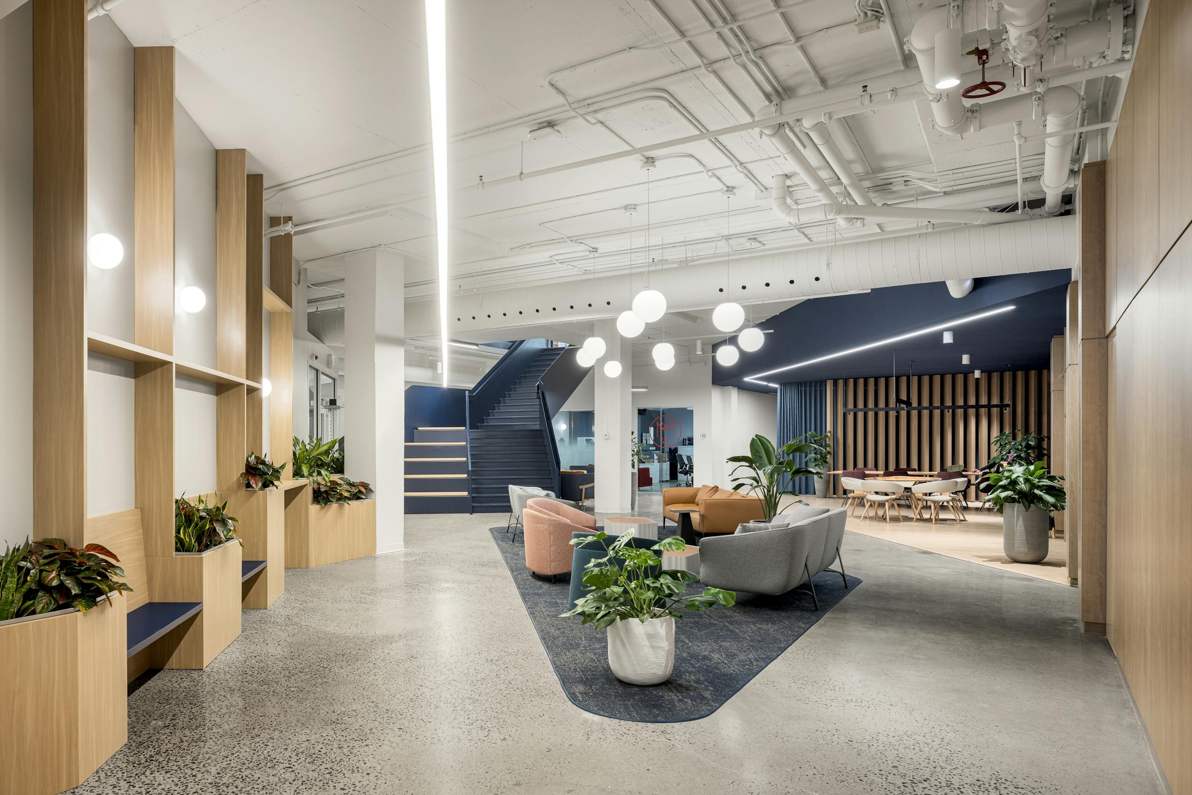 Photographie intérieure d’un environnement de travail avec aménagement biophilique et mobilier contemporain.