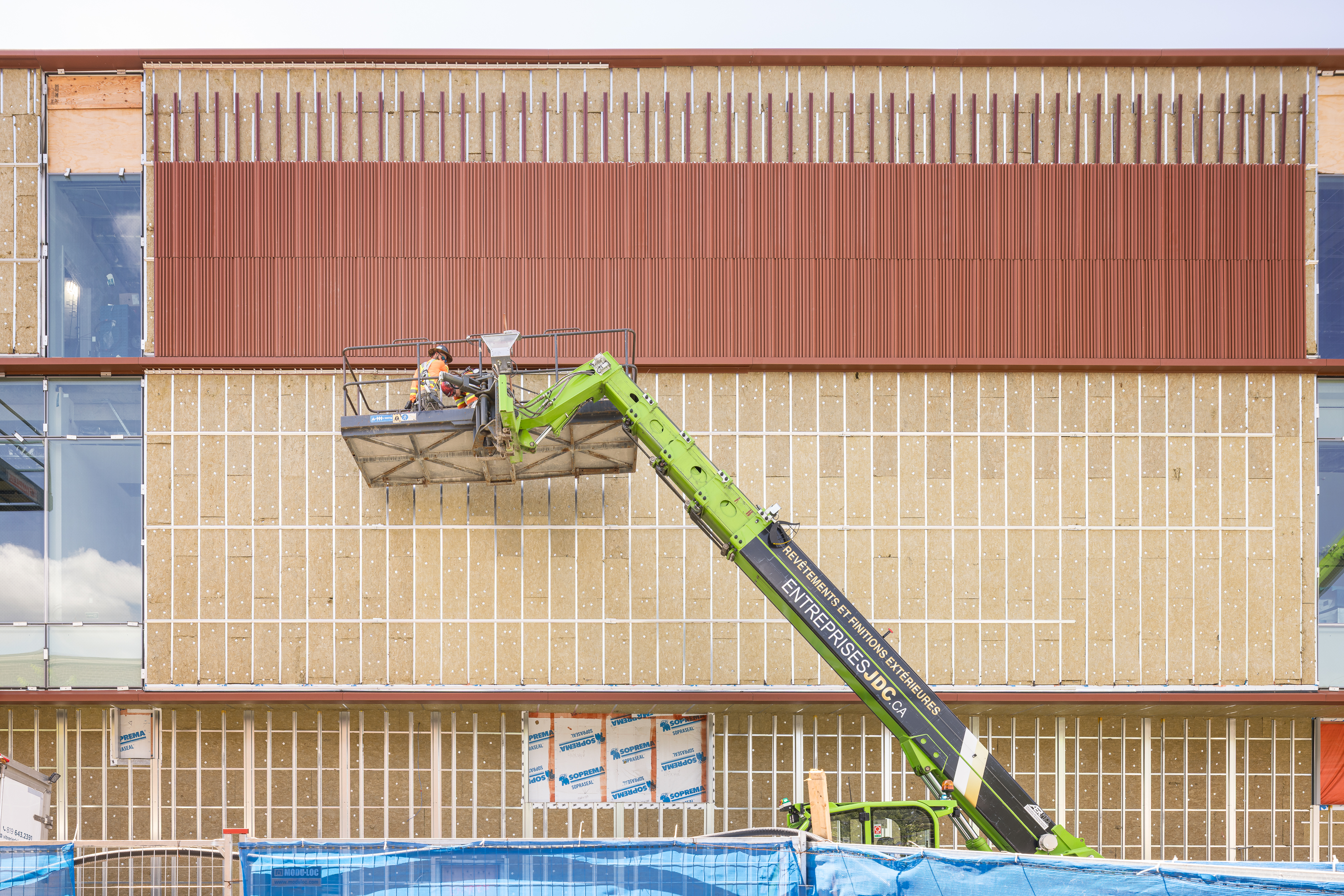 Détail de la façade montrant la pose du revêtement en terra cotta sur structure temporaire.