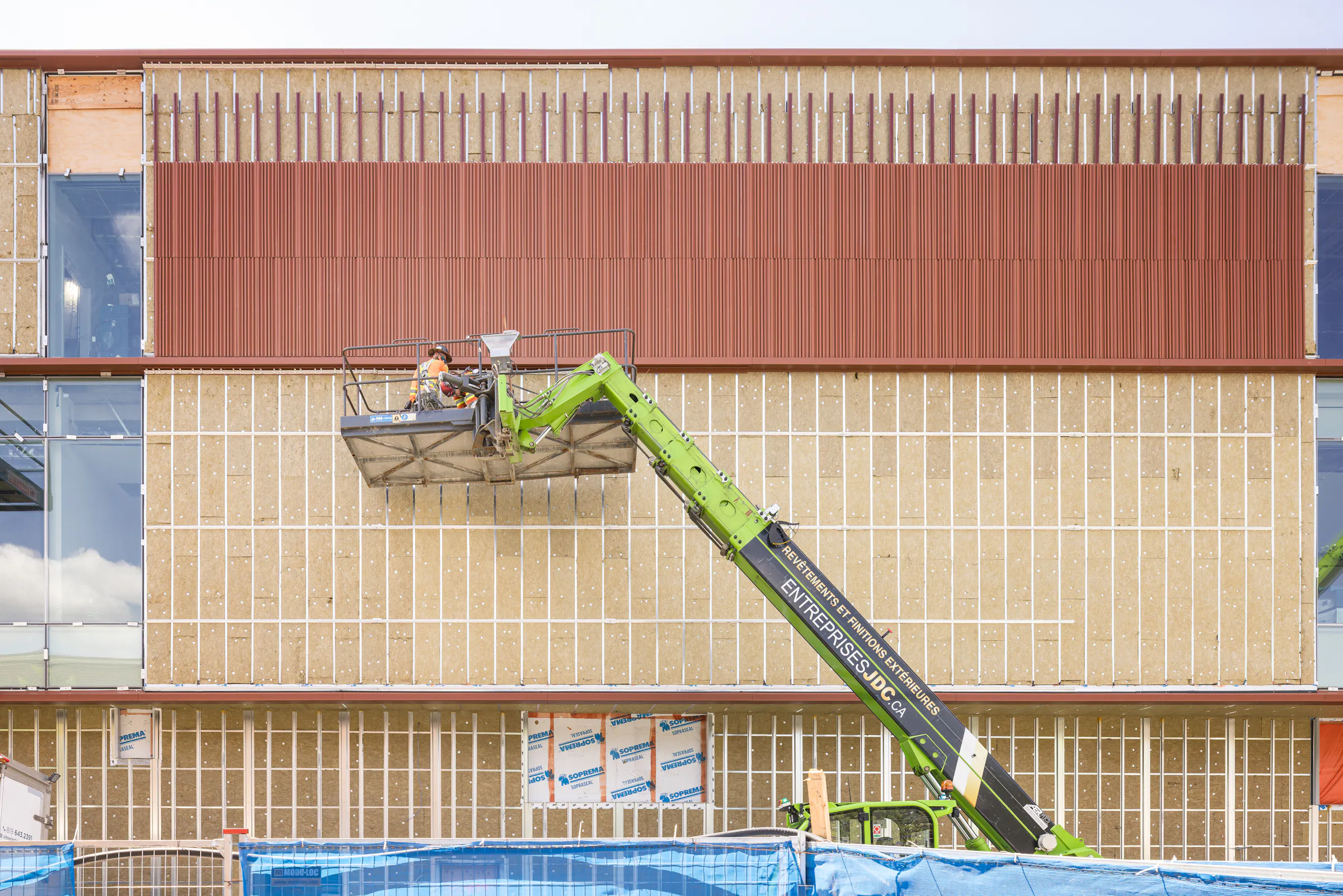 Détail de la façade montrant la pose du revêtement en terra cotta sur structure temporaire.