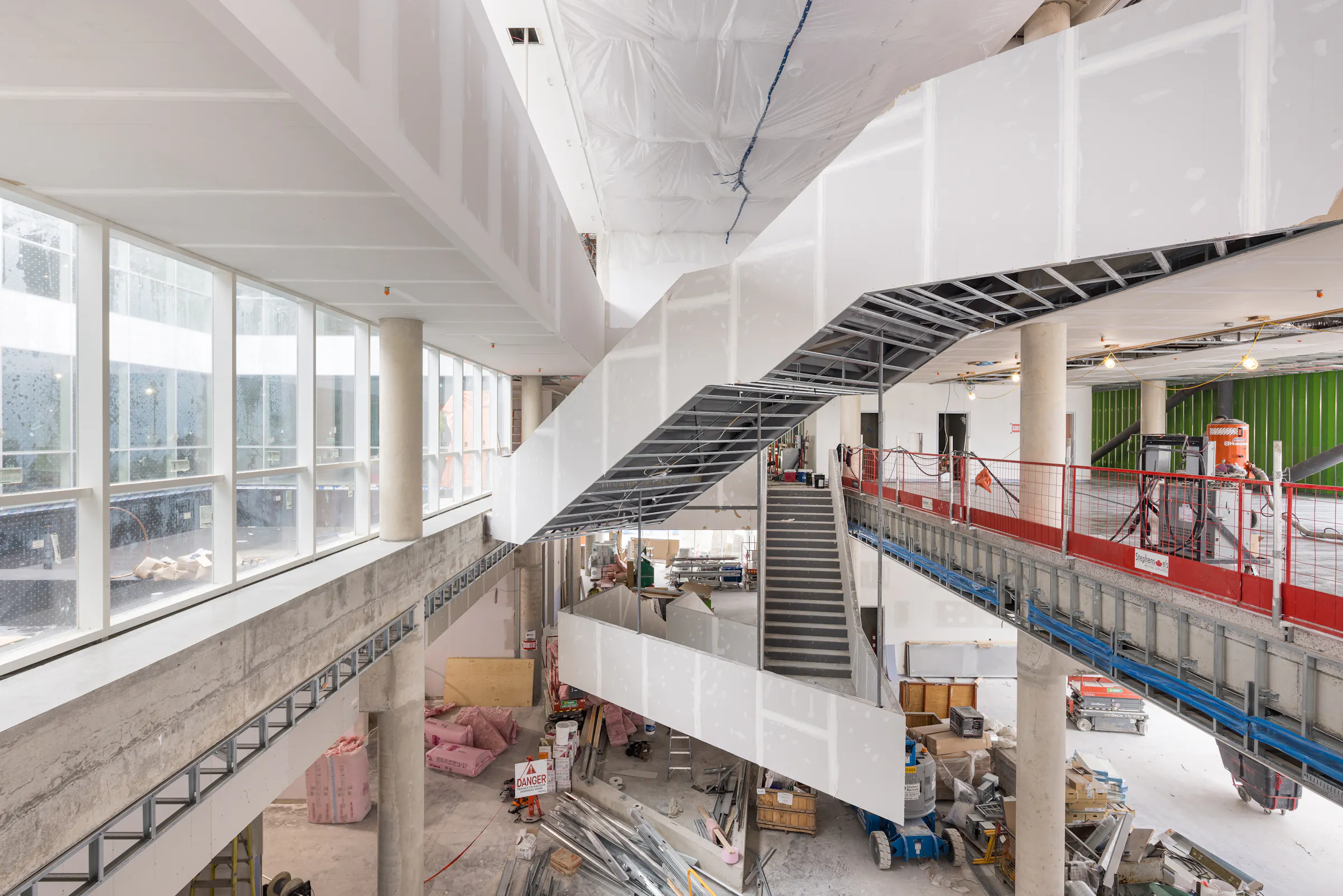 Espace central de la bibliothèque avec structure apparente et circulation verticale.
