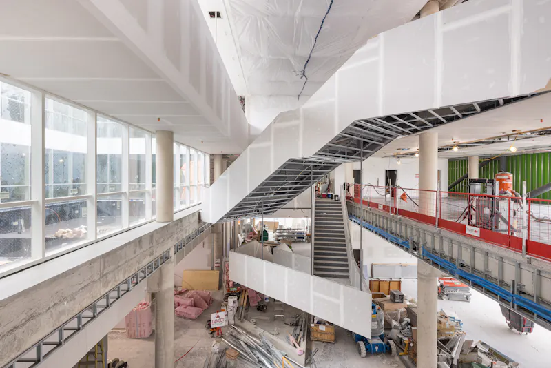 Espace central de la bibliothèque avec structure apparente et circulation verticale.