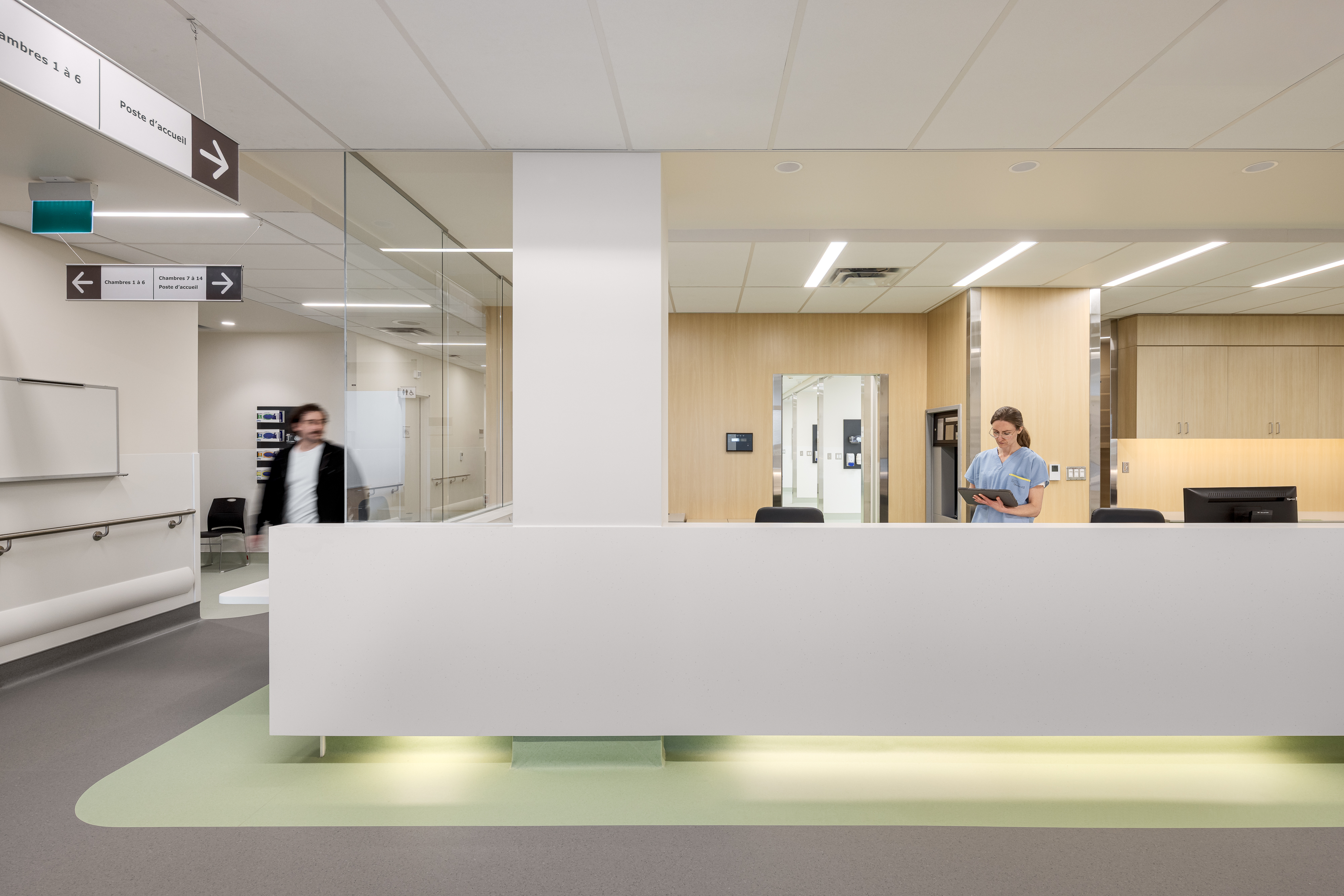Comptoir d’accueil clinique avec personnel soignant, mettant en valeur le design et l’architecture hospitalière.