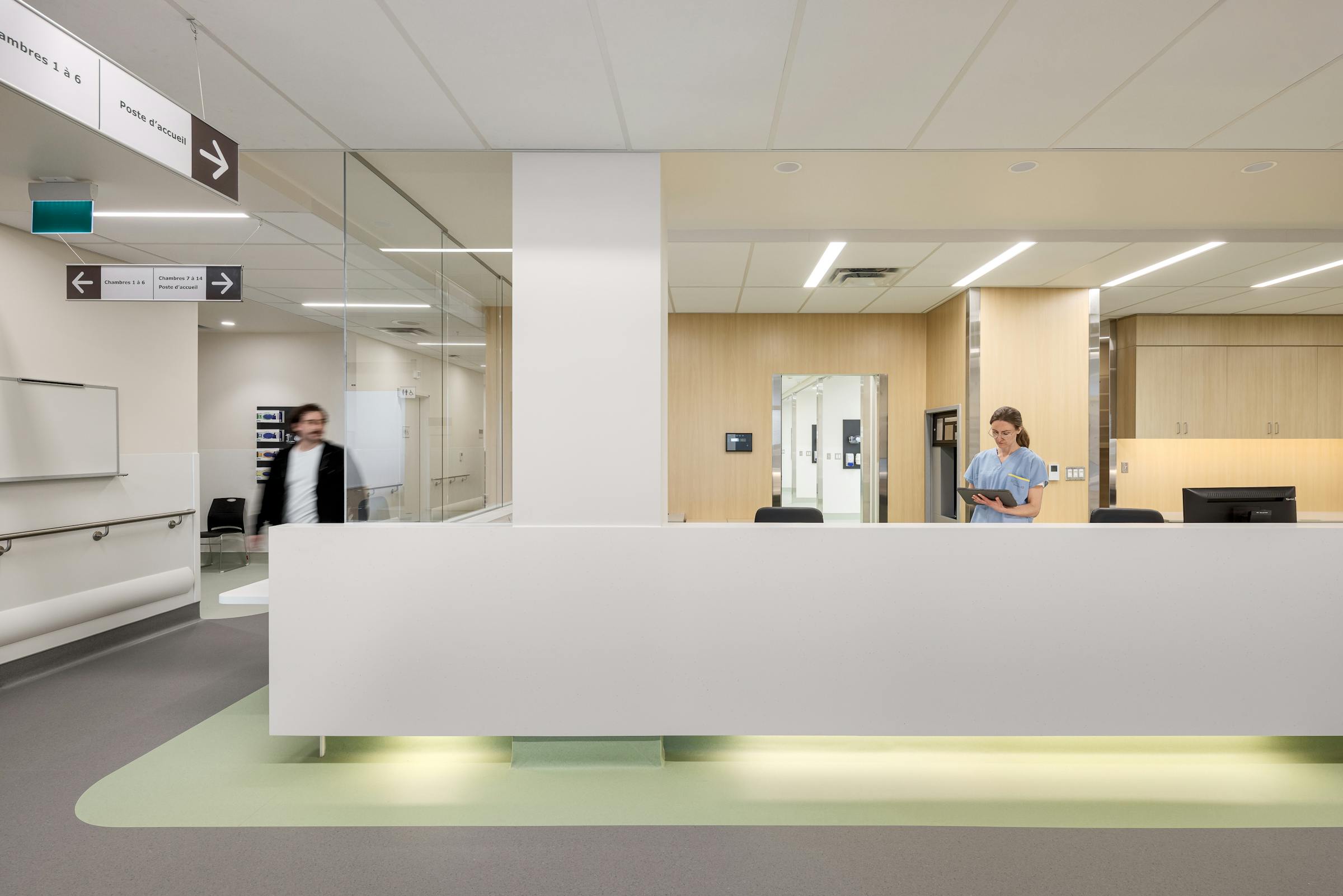 Comptoir d’accueil clinique avec personnel soignant, mettant en valeur le design et l’architecture hospitalière.