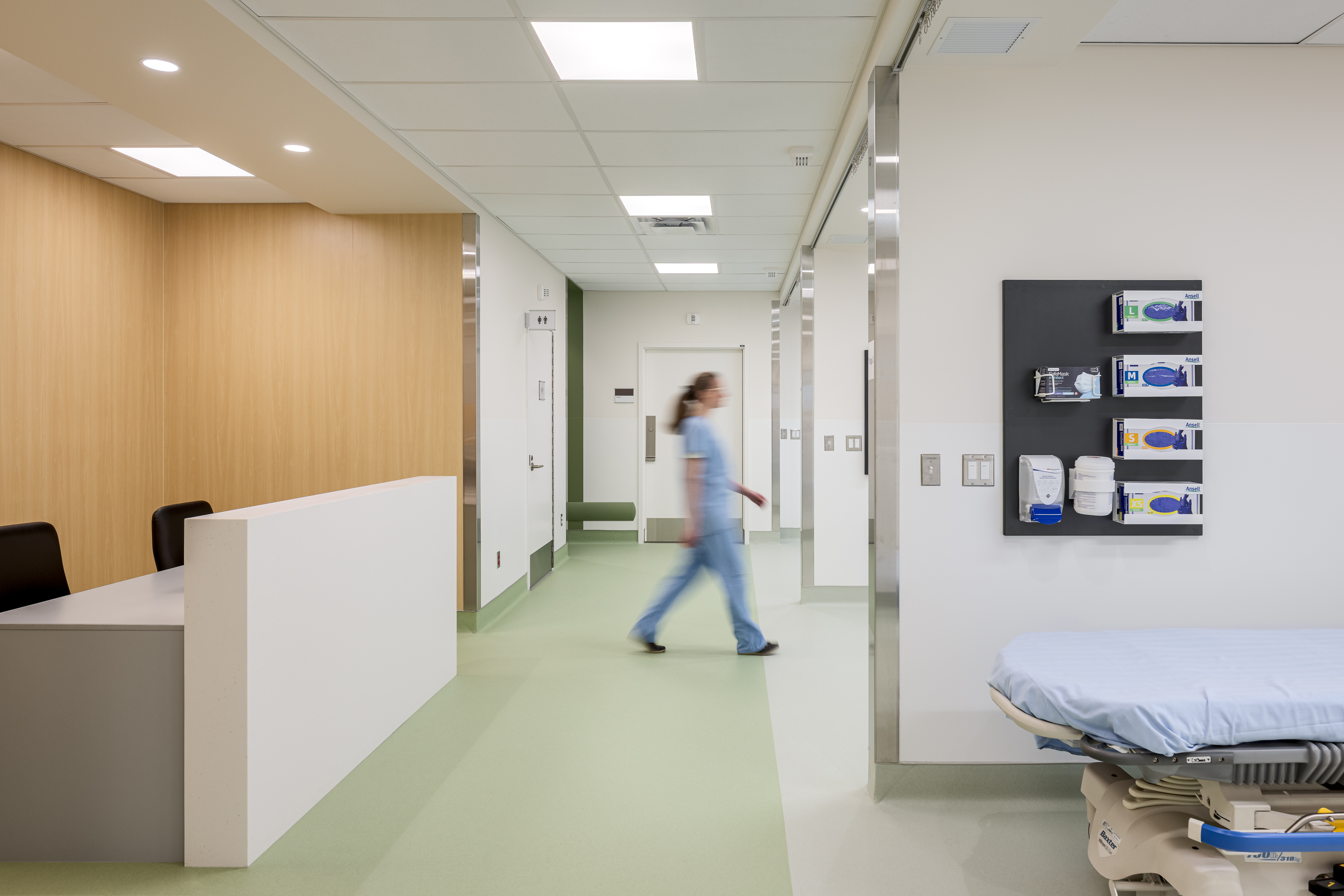 Zone de soins hospitalière avec circulation ouverte et matériaux durables, captée en photographie d’architecture.