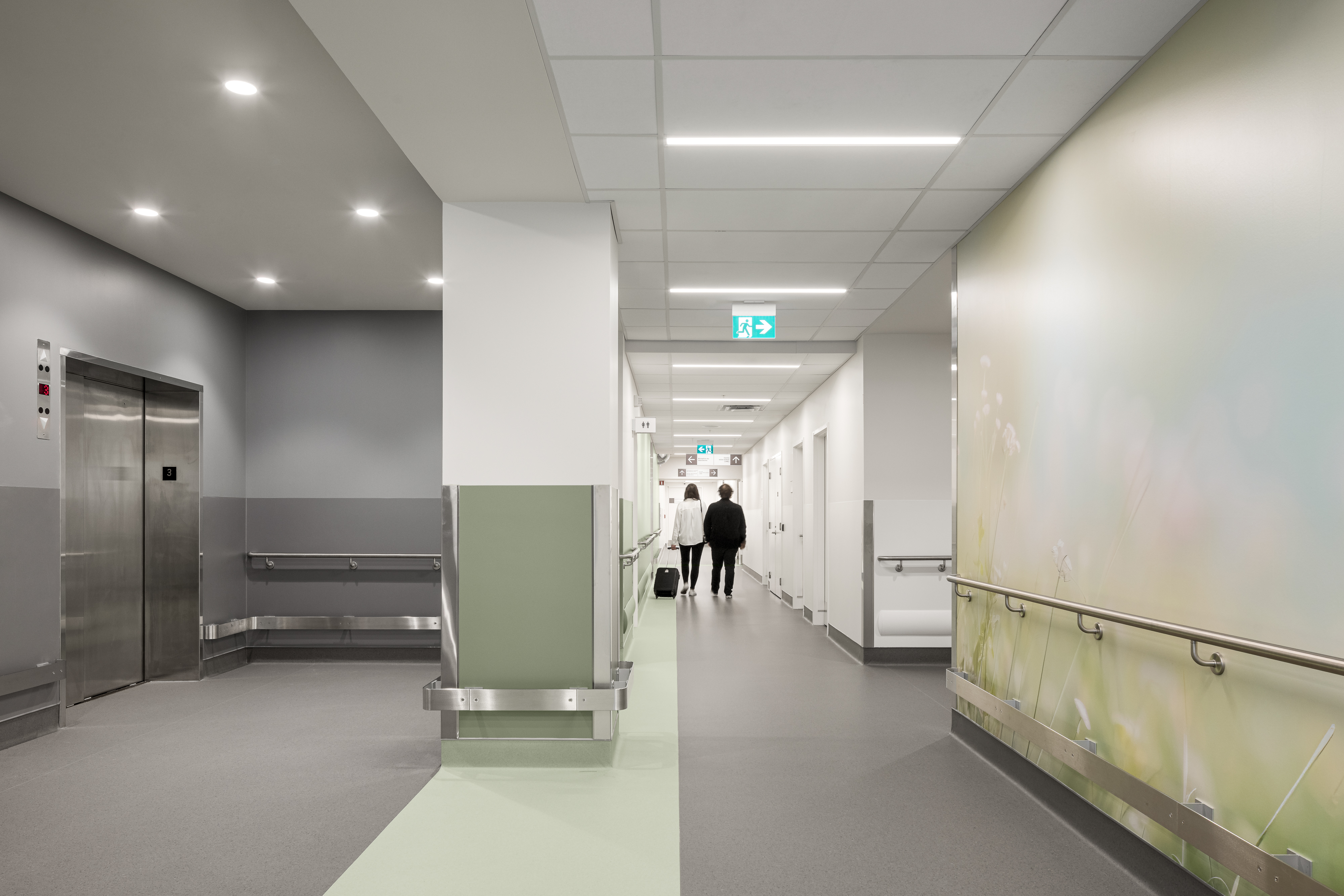 Architecture intérieure d’hôpital avec ascenseurs et circulation centrale, captée en photographie grand angle.