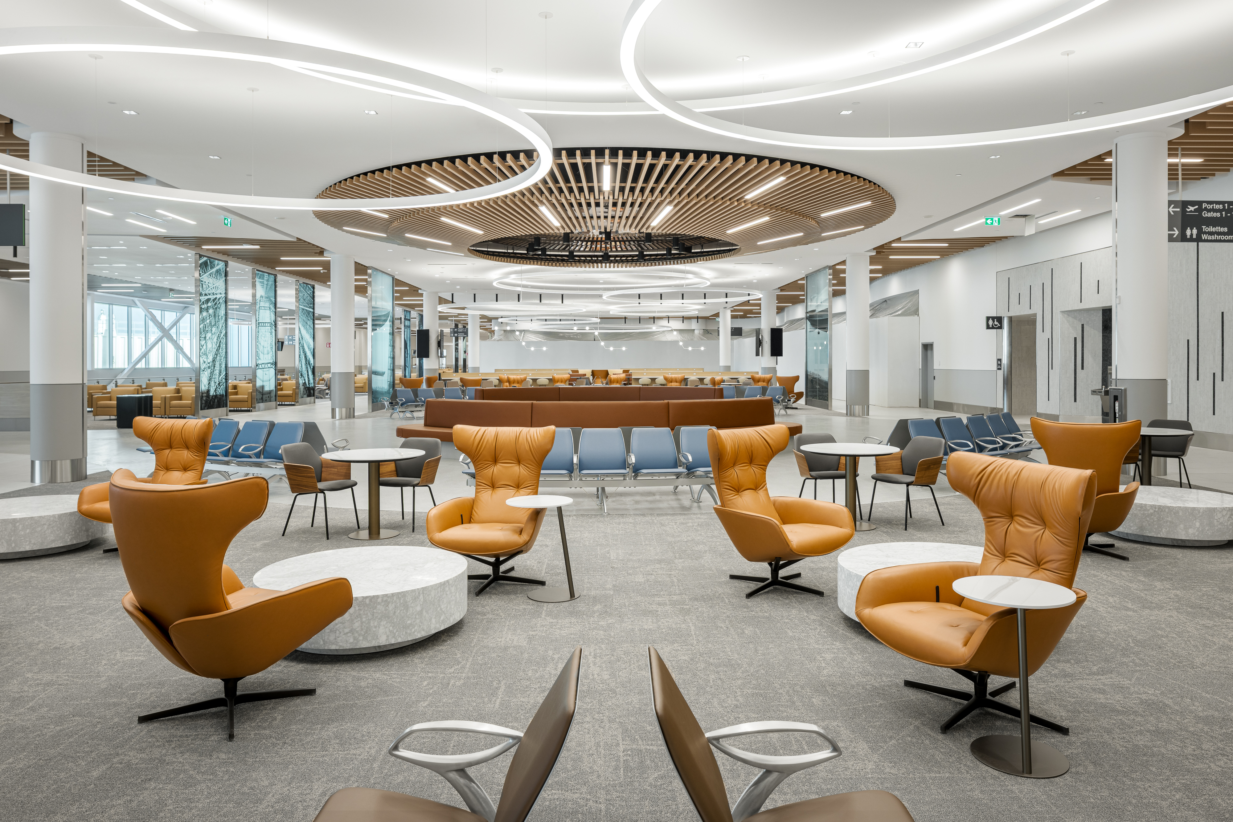 Salon d’attente de l’aéroport avec mobilier contemporain et éclairage architectural.