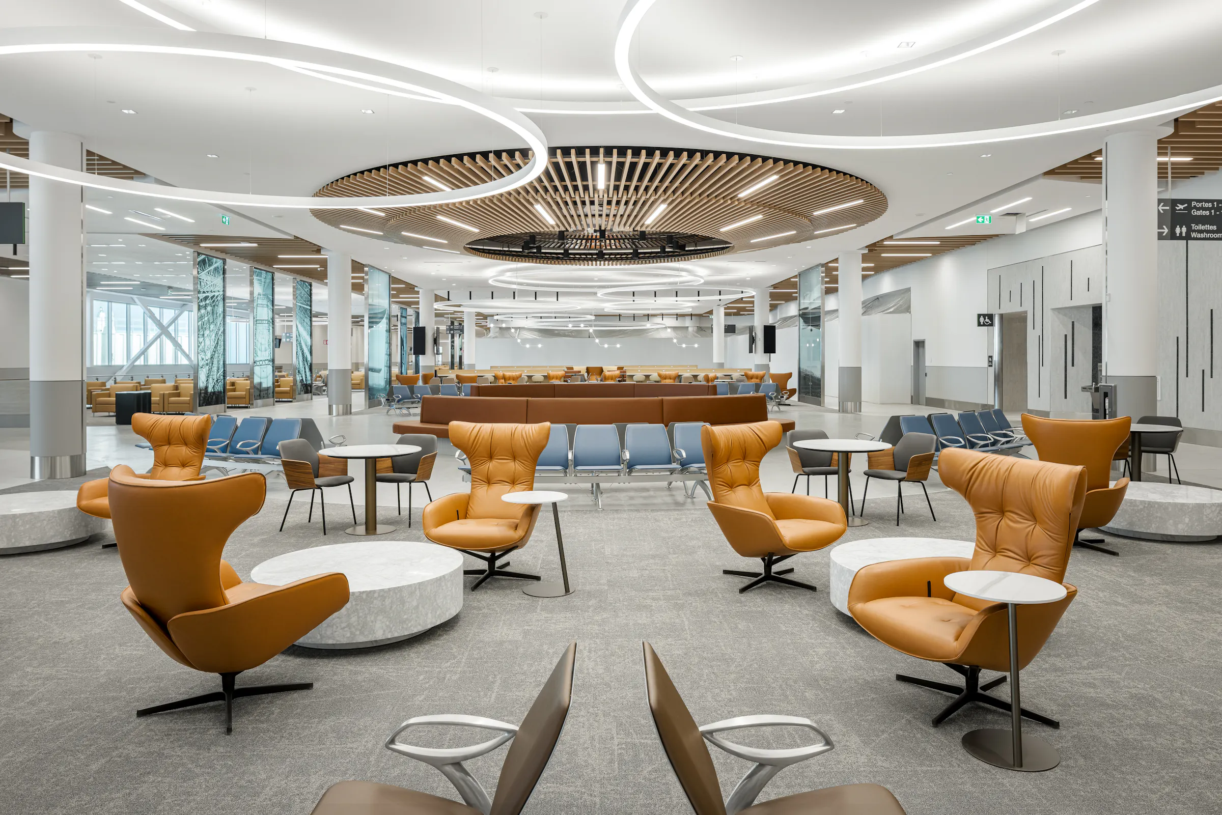 Salon d’attente de l’aéroport avec mobilier contemporain et éclairage architectural.