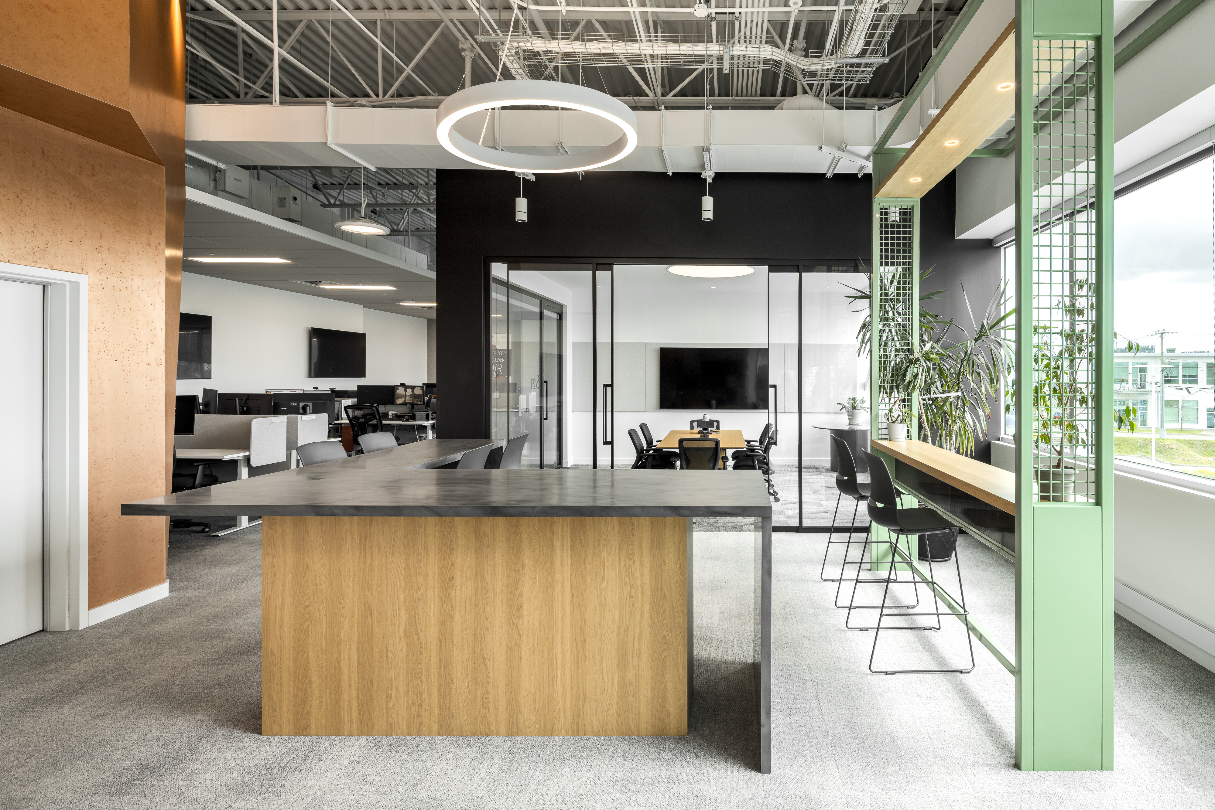 Photographie d’architecture d’un espace collaboratif avec îlot central en bois, plafond industriel et design intérieur contemporain.