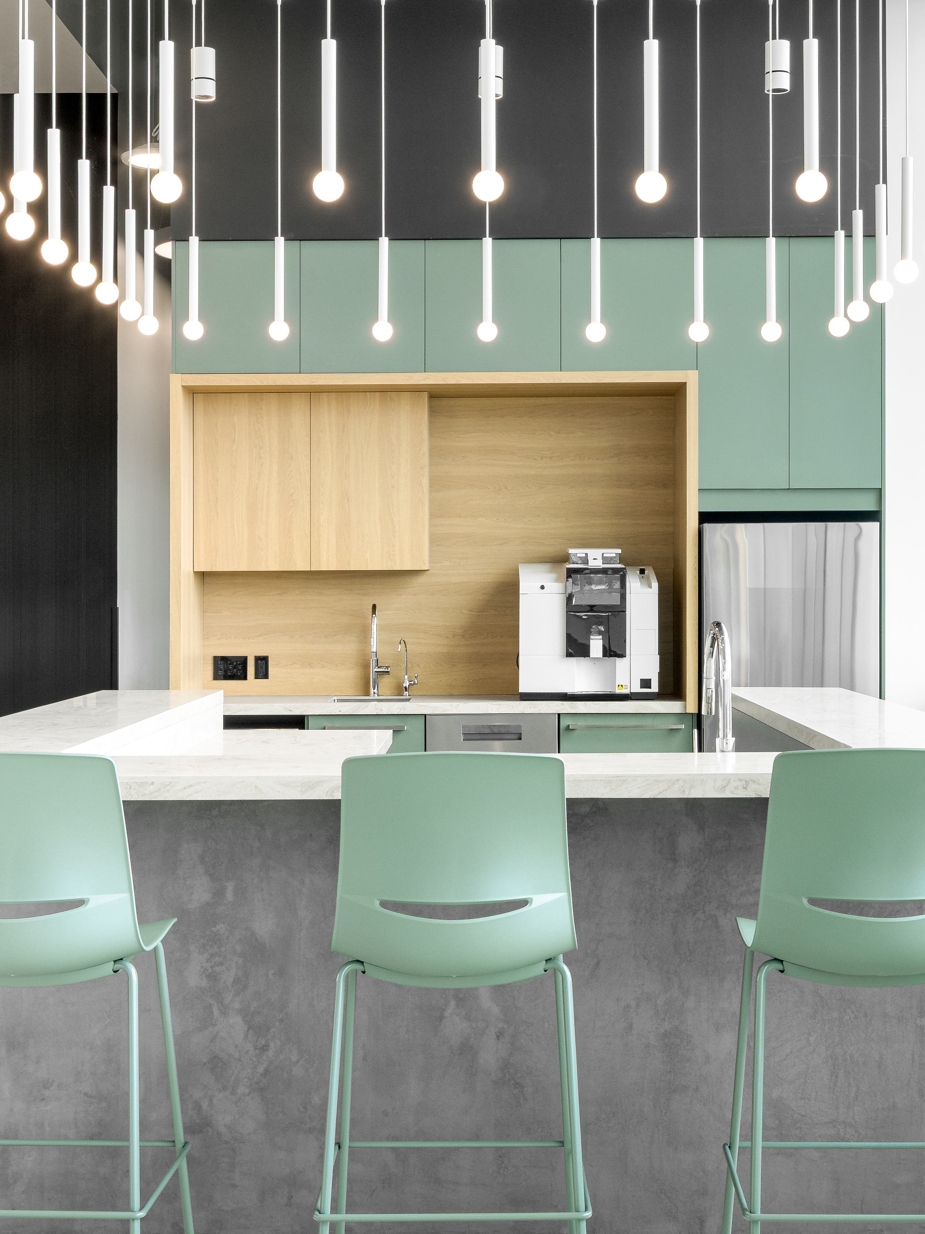 Photographie d’architecture d’un espace café moderne avec comptoir en bois, design intérieur minimaliste et éclairage décoratif.