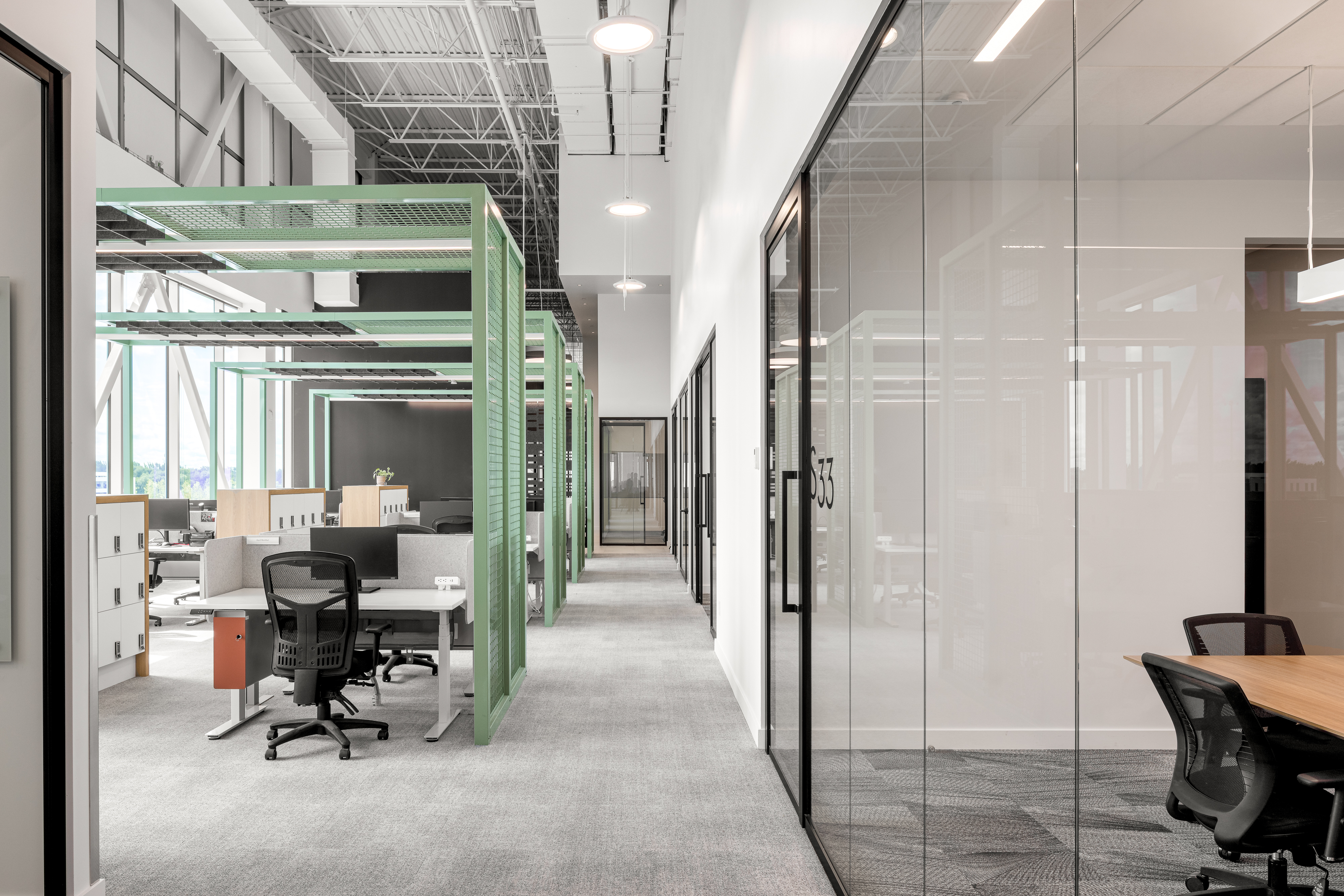 Photographie d’architecture d’un corridor de bureaux modernes avec structure apparente, design intérieur et lumière naturelle.