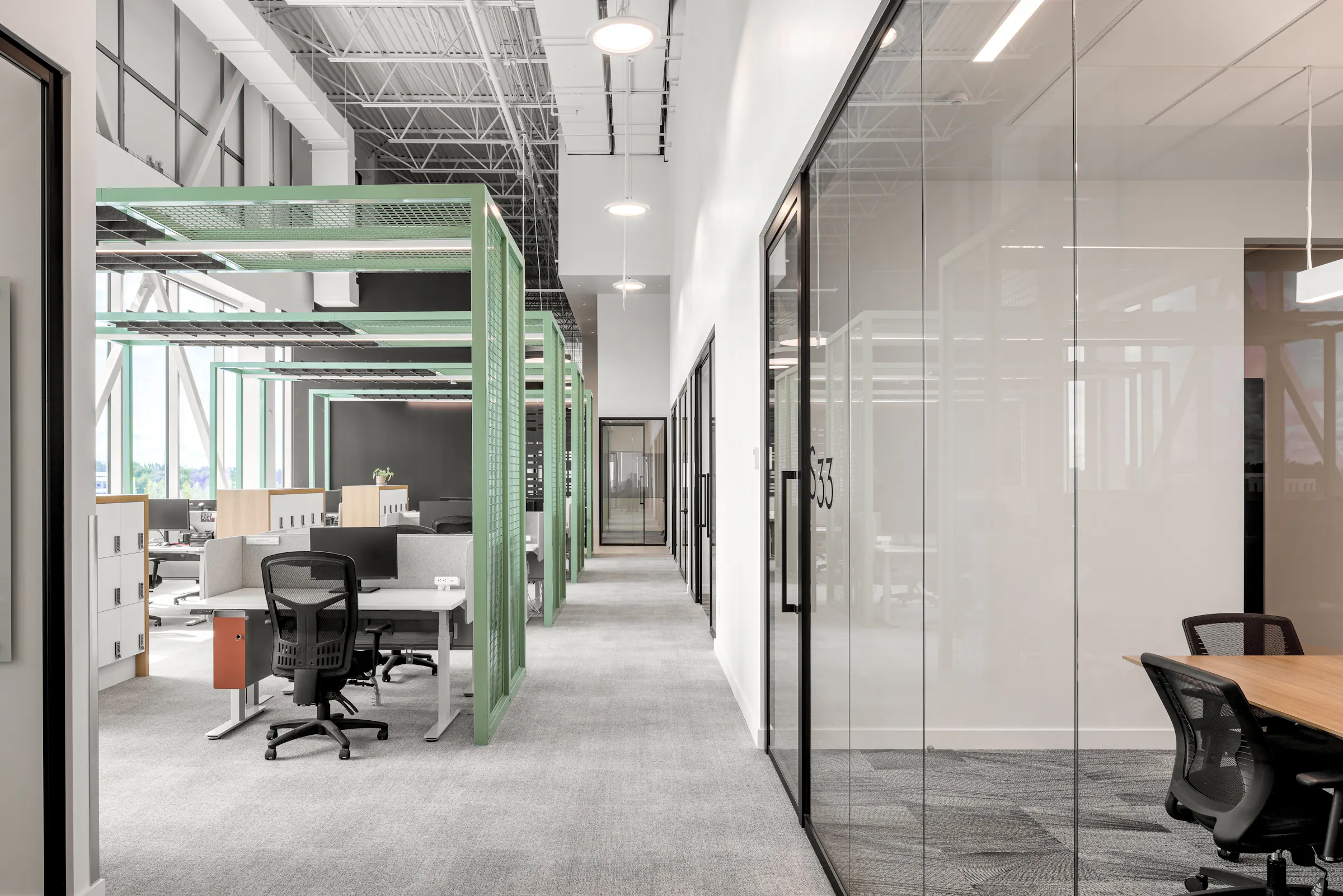 Photographie d’architecture d’un corridor de bureaux modernes avec structure apparente, design intérieur et lumière naturelle.