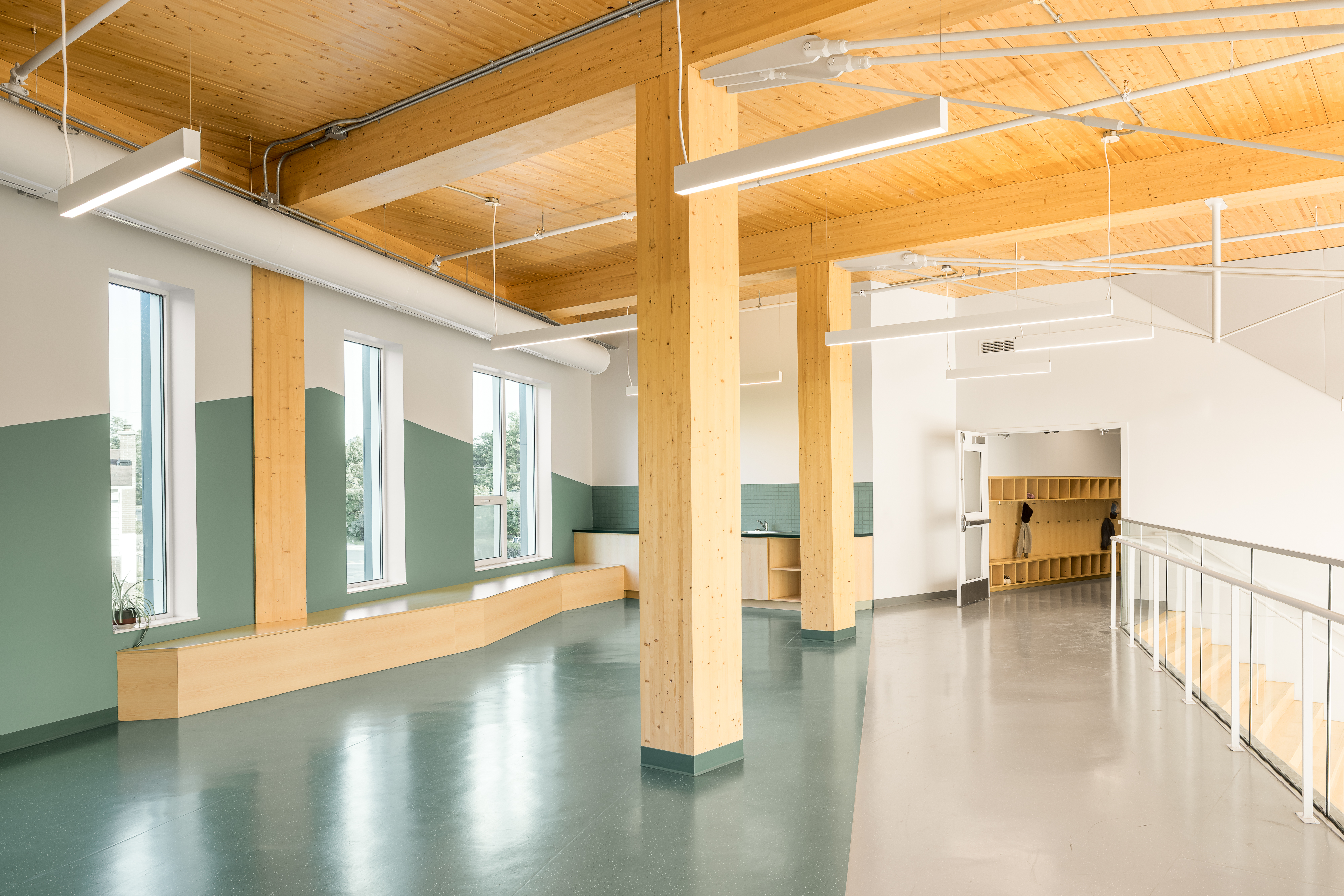 Photographie d’architecture d’un espace ouvert dans une école contemporaine avec structure en bois et design intérieur minimaliste.