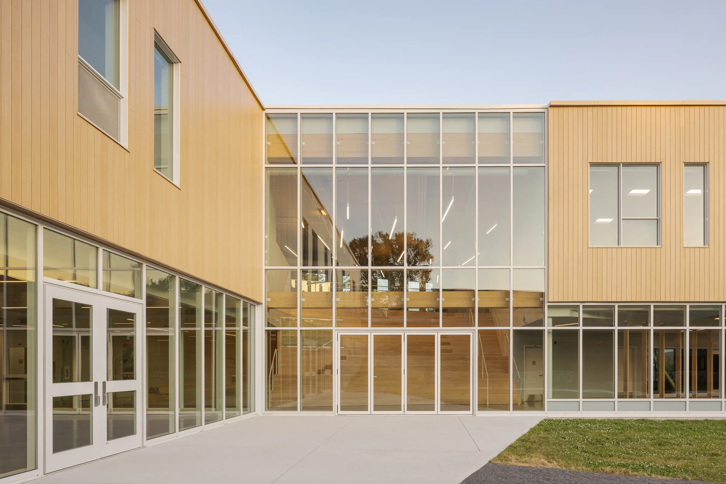 Photographie d’architecture d’un bâtiment scolaire moderne avec design contemporain et circulation extérieure.