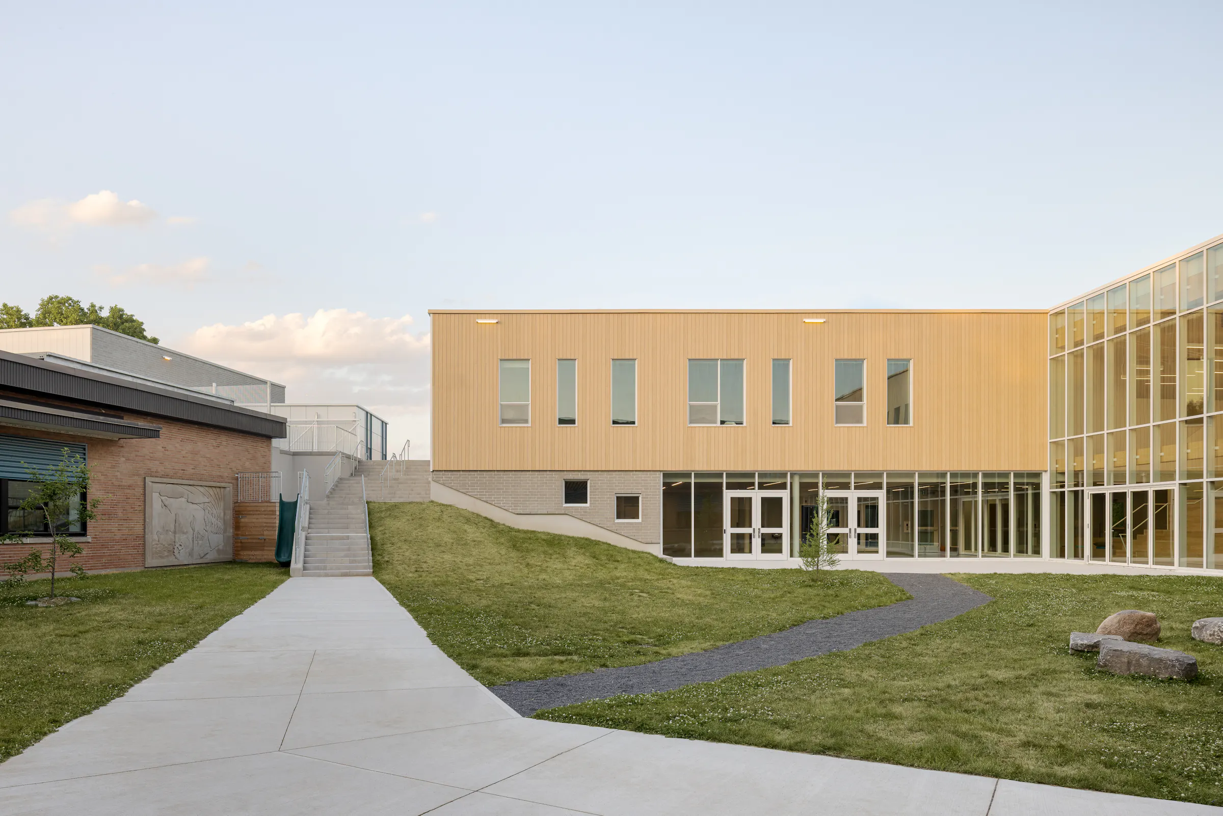 Photographie d’architecture d’un bâtiment scolaire moderne à Gatineau avec façade en bois et grandes surfaces vitrées.