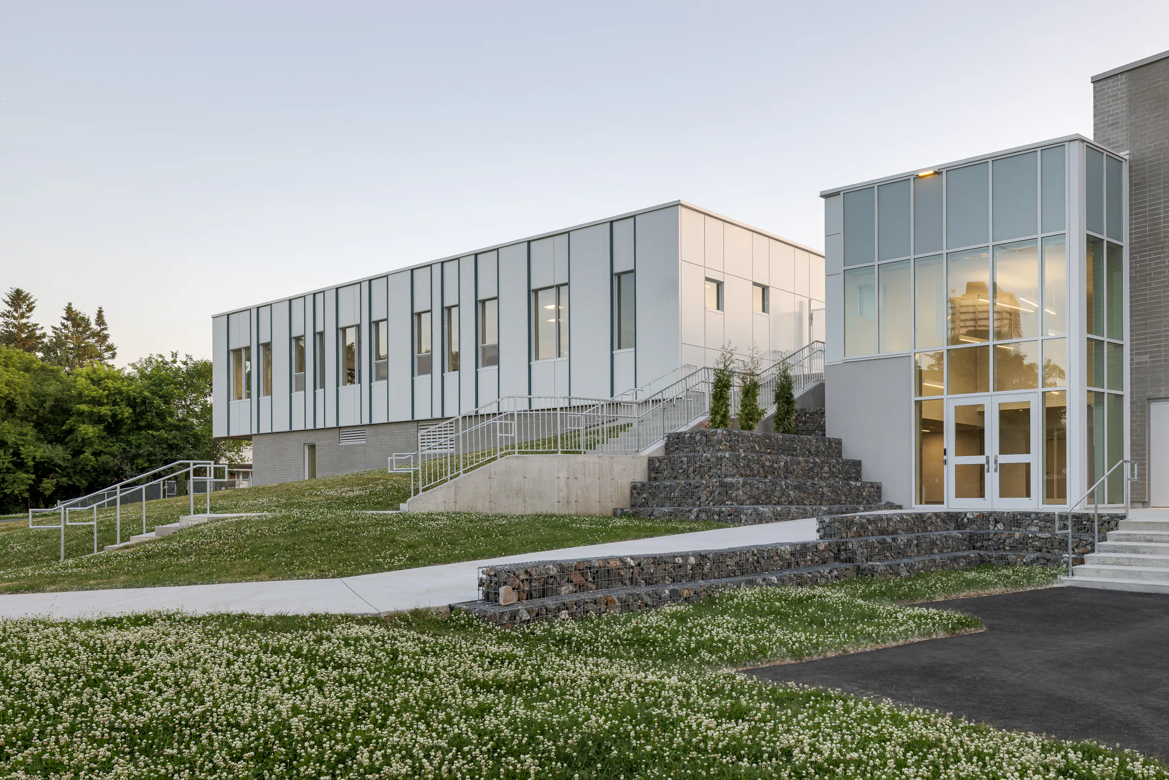 Photographie d’architecture d’un bâtiment scolaire moderne avec escalier extérieur et design contemporain.