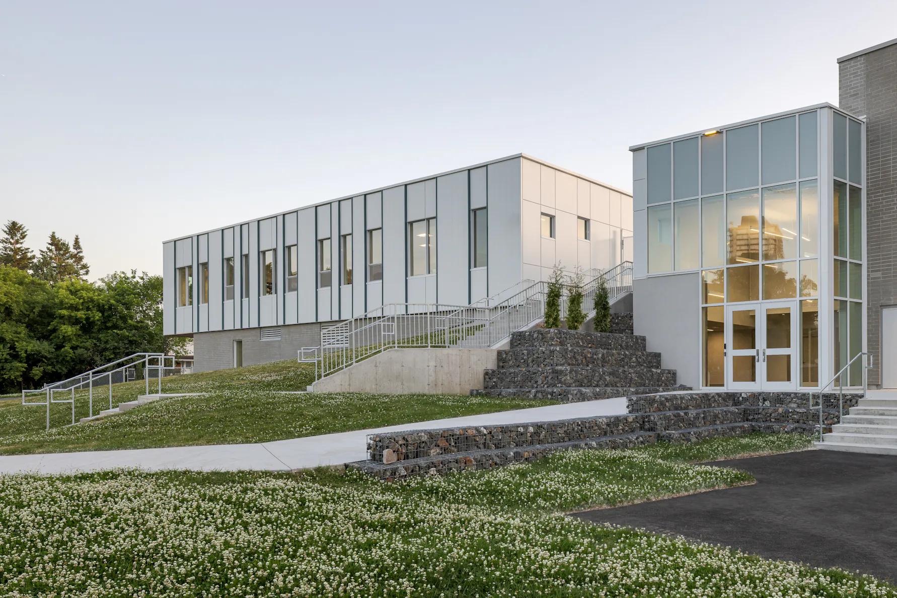 Photographie d’architecture d’un bâtiment scolaire moderne avec escalier extérieur et design contemporain.