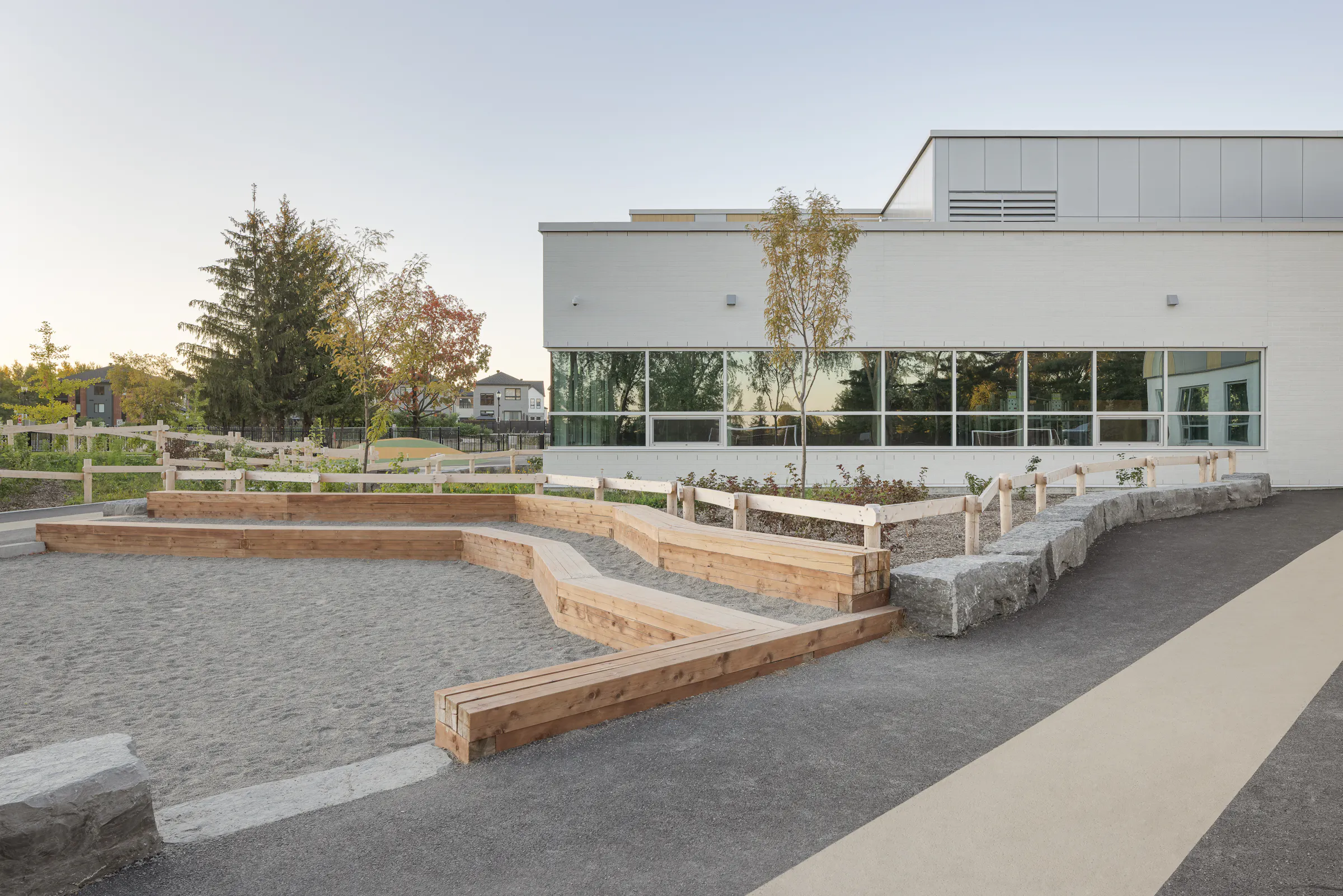 Aménagements extérieurs en gradins de l'École des Saules, L'Assomption. Murets de bois et espaces de jeu intégrés. Photo : TARMAC - Damien Ligiardi.