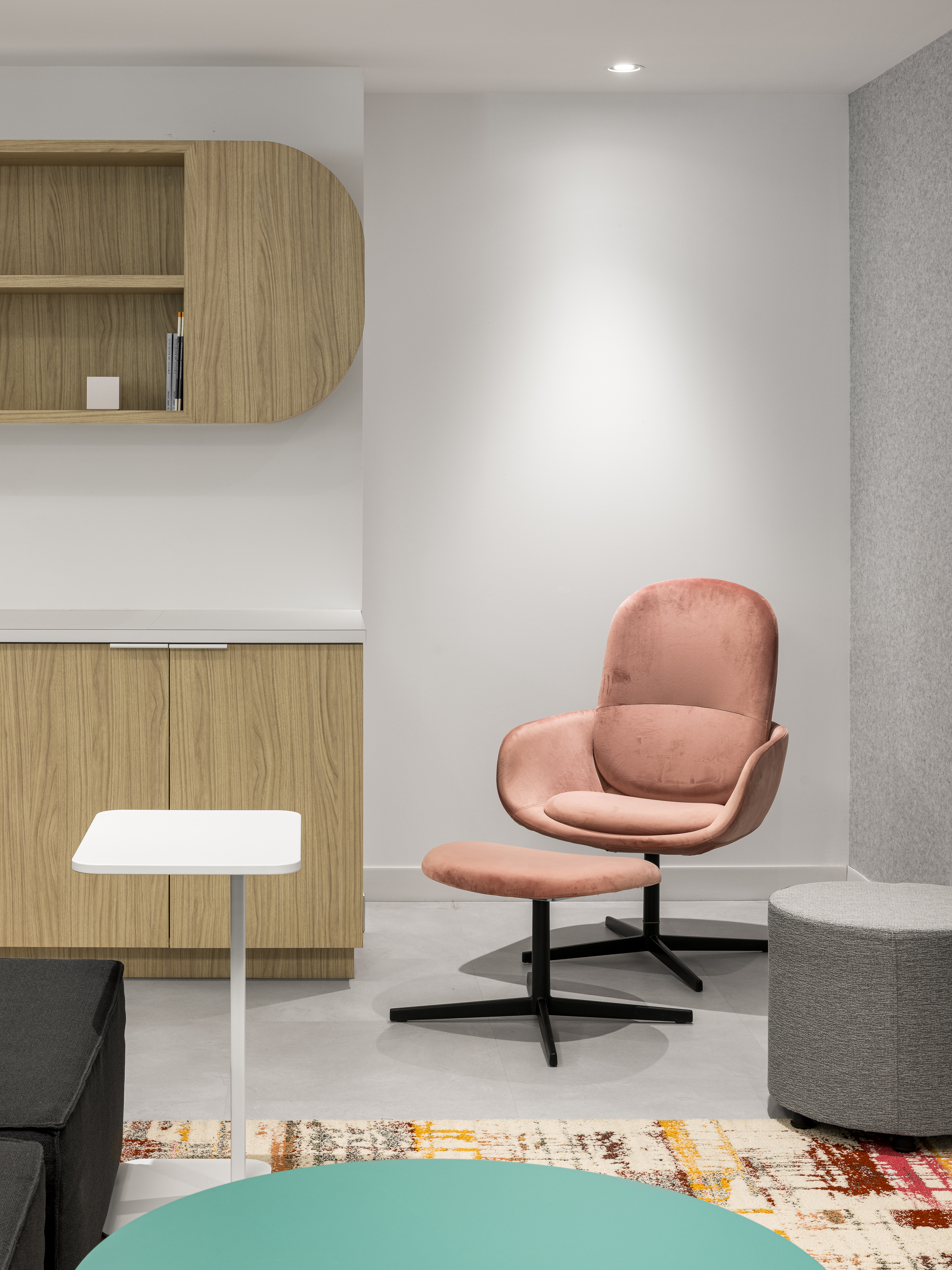 Niche de travail individuel avec fauteuil rose et lampe sur pied, dans les bureaux d'Airport Council International, Place Victoria, Montréal. Photo : TARMAC - Damien Ligiardi
