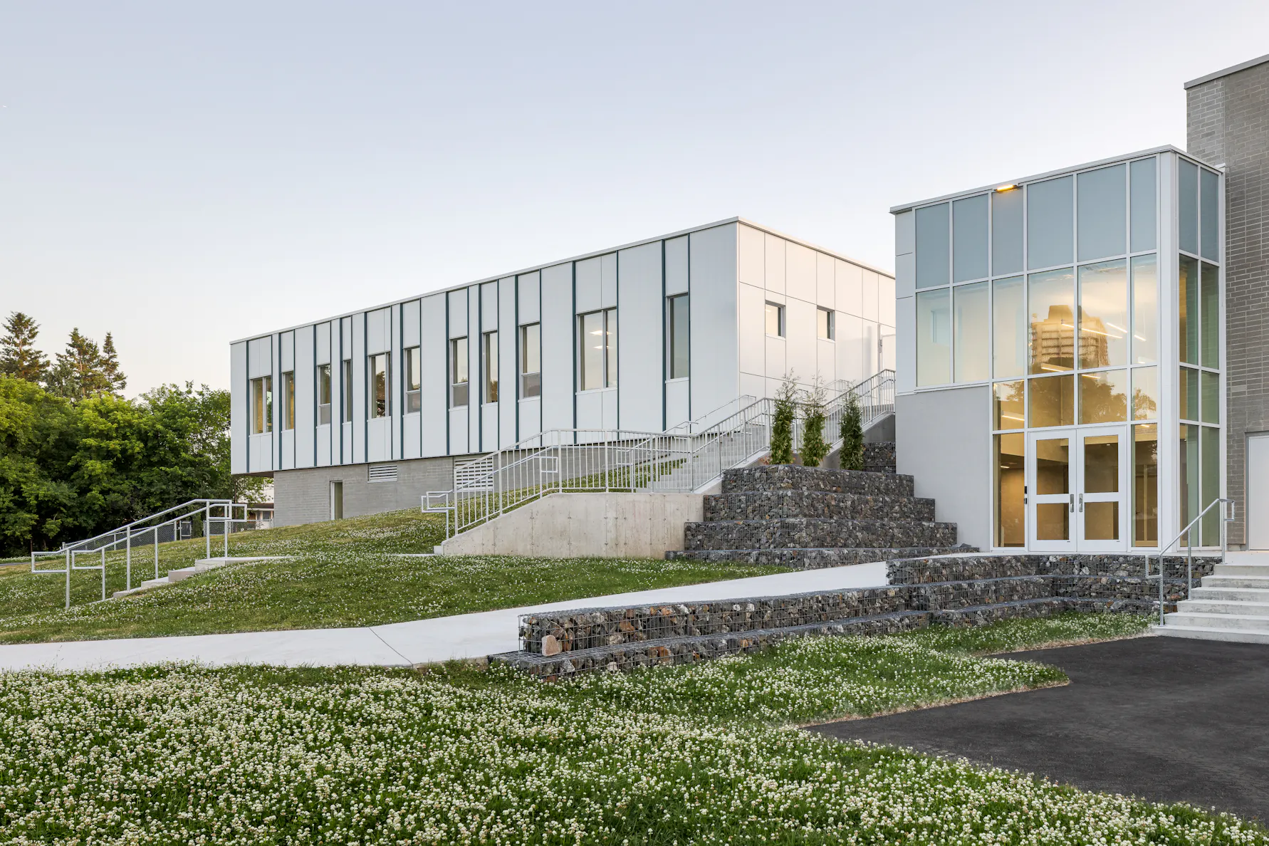 Photographie d’architecture d’un bâtiment scolaire moderne avec escalier extérieur et design contemporain.