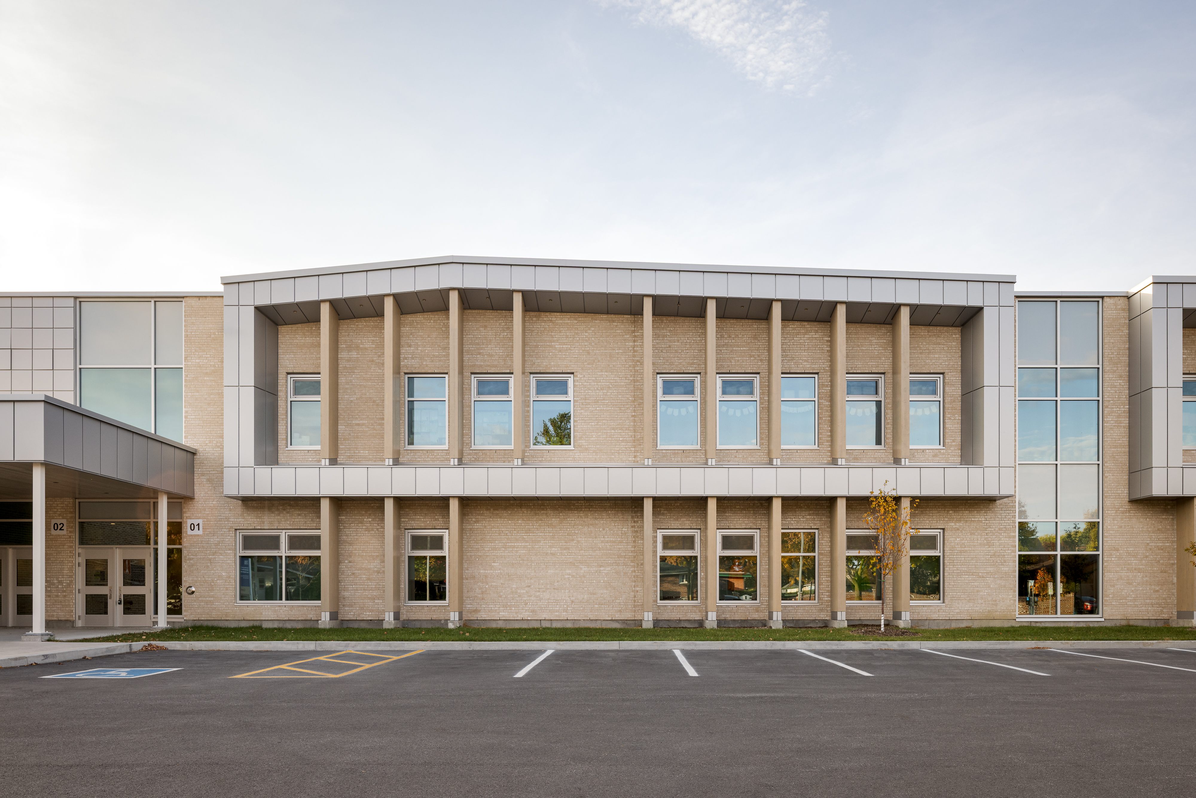 Main facade of Bois-Joli–Sacré-Coeur school, entrance to the new wing with concrete columns and pale brick cladding. Photo: TARMAC - Damien Ligiardi