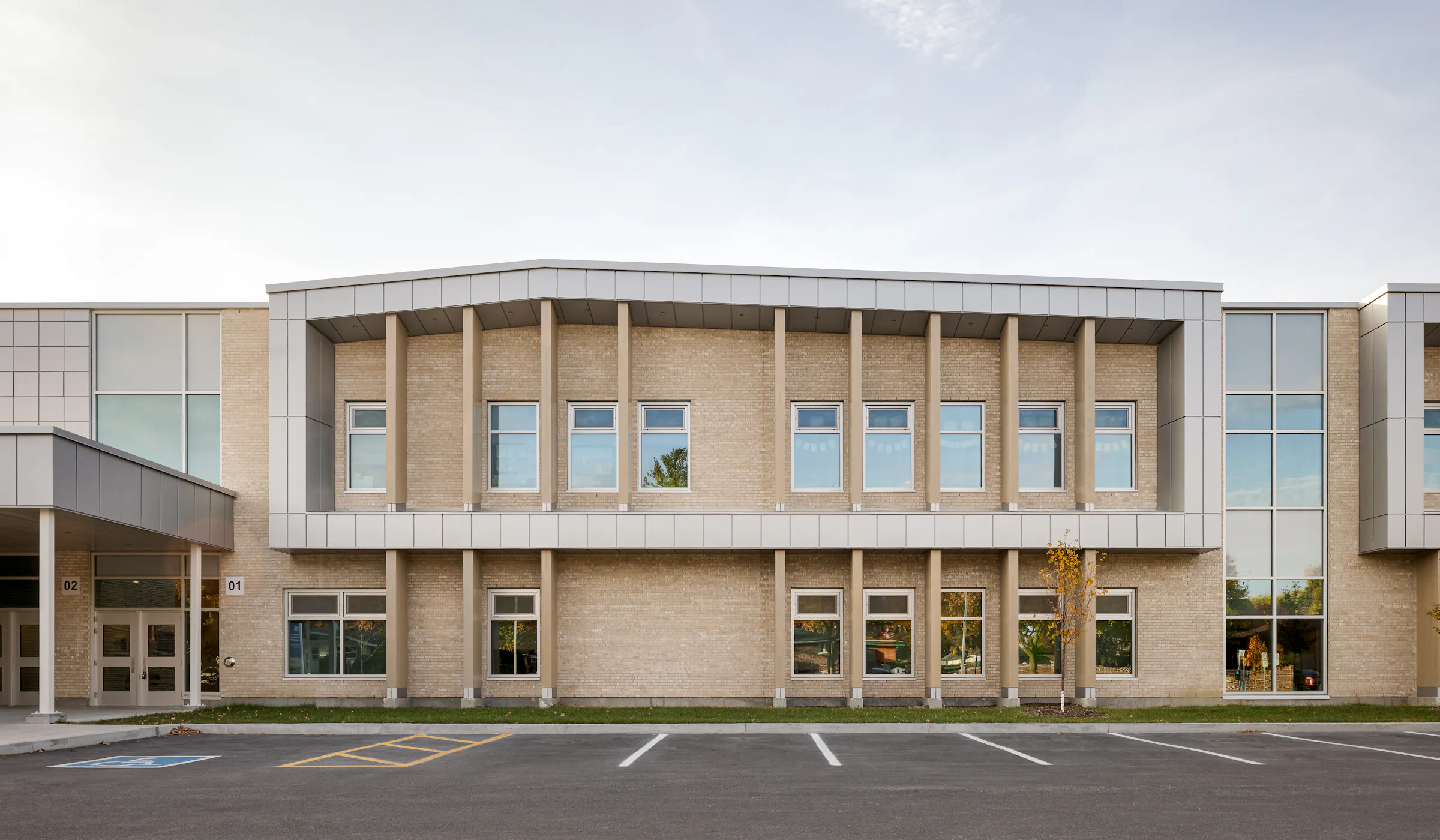 Main facade of Bois-Joli–Sacré-Coeur school, entrance to the new wing with concrete columns and pale brick cladding. Photo: TARMAC - Damien Ligiardi