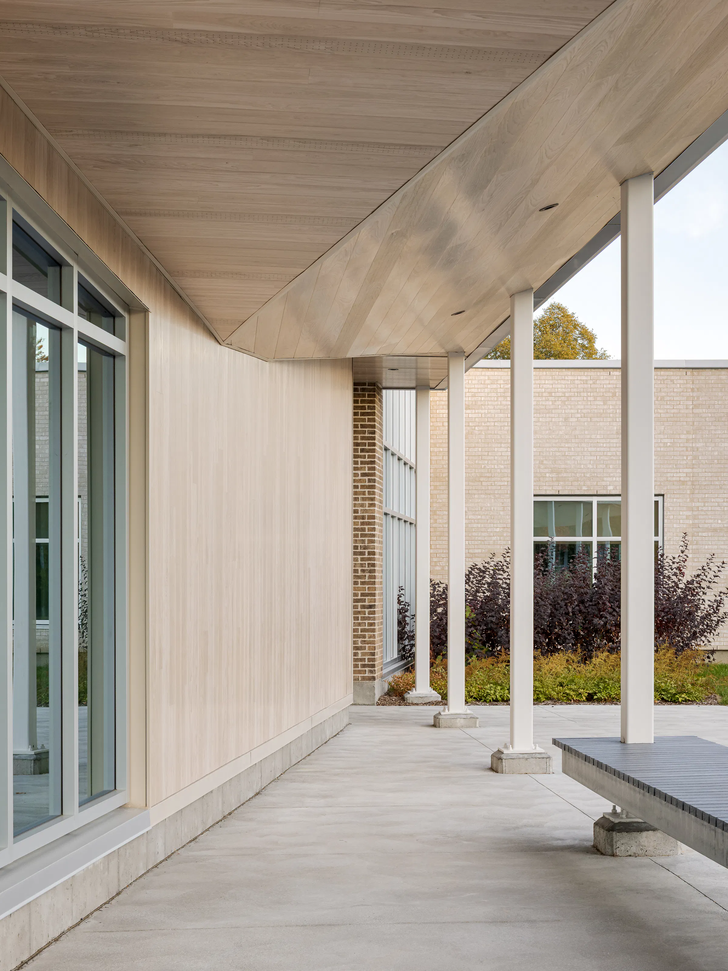 View of the inner courtyard from the covered passageway, with concrete columns and a glass roof in the foreground. Photo: TARMAC - Damien Ligiardi