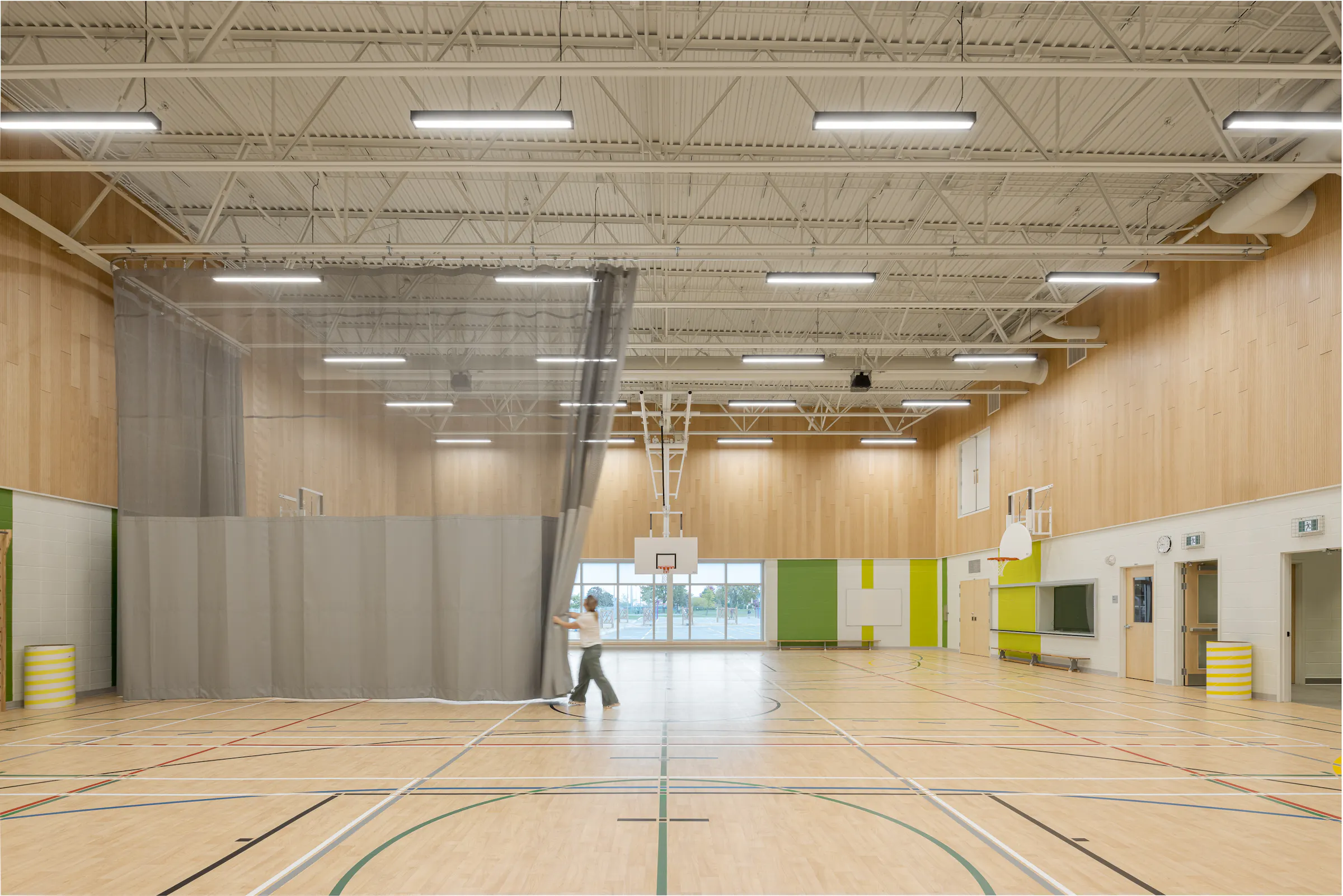 Overview of the double gymnasium, wooden walls and sports equipment, high ceilings. Photo: TARMAC - Damien Ligiardi